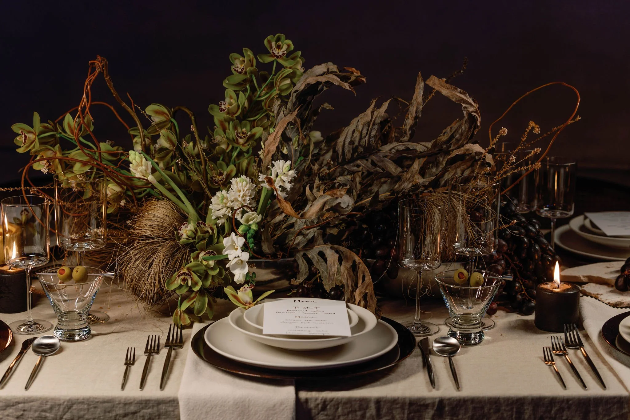 Elegant table setting with flowers, candles, glassware, and plates