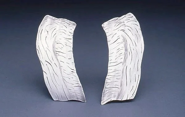 Groundswell, Earrings, 1980.
Sterling silver.  Drawn from the sculpture installation Groundswell.  
3 inches tall