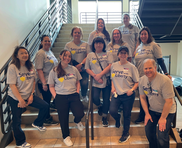 Volunteers from Liberty Mutual posting on the stairs outside the pantry