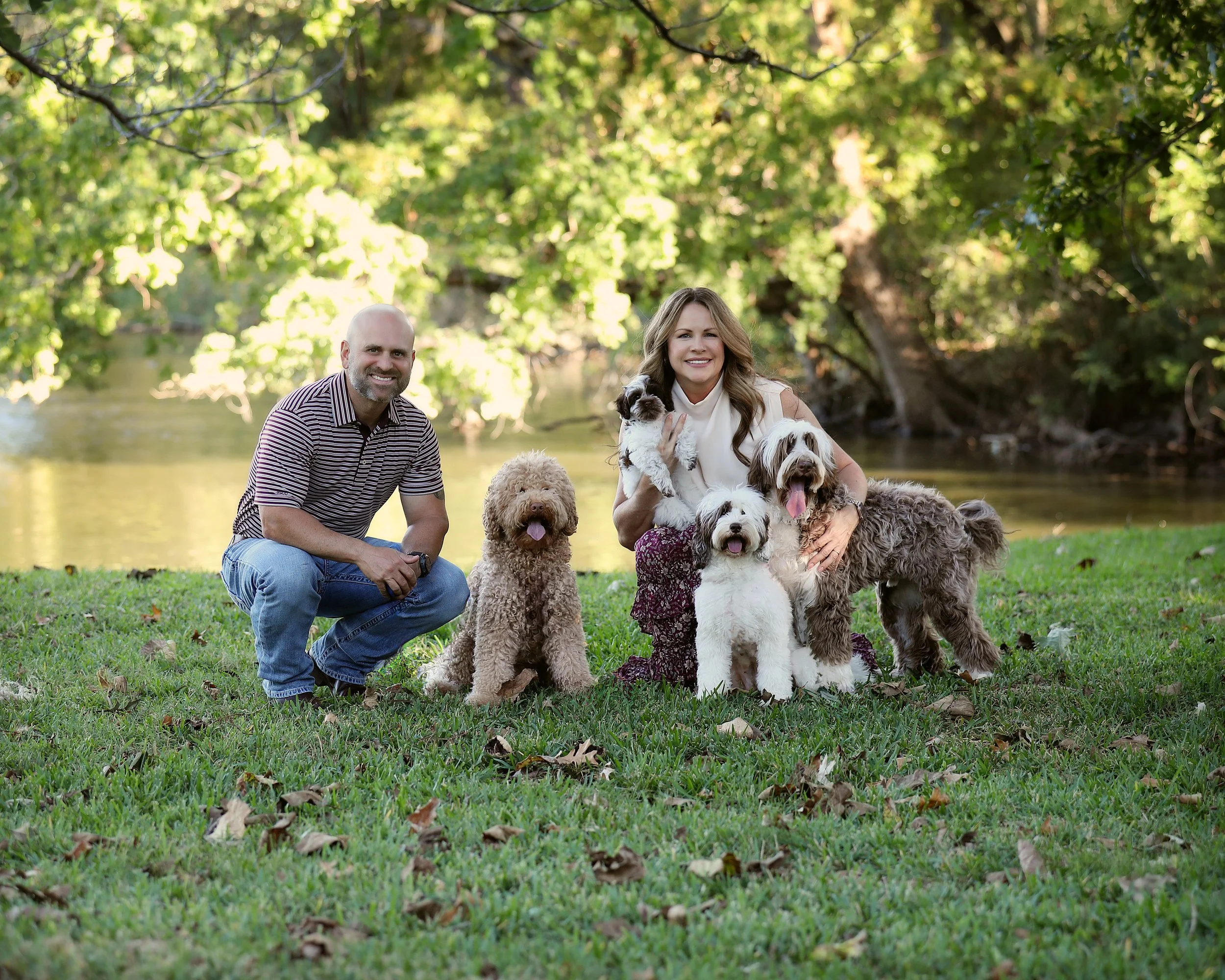 Sugar Cane Doodle owners Kristin and Francisco Zatta with three Australian labradoodles by the lake