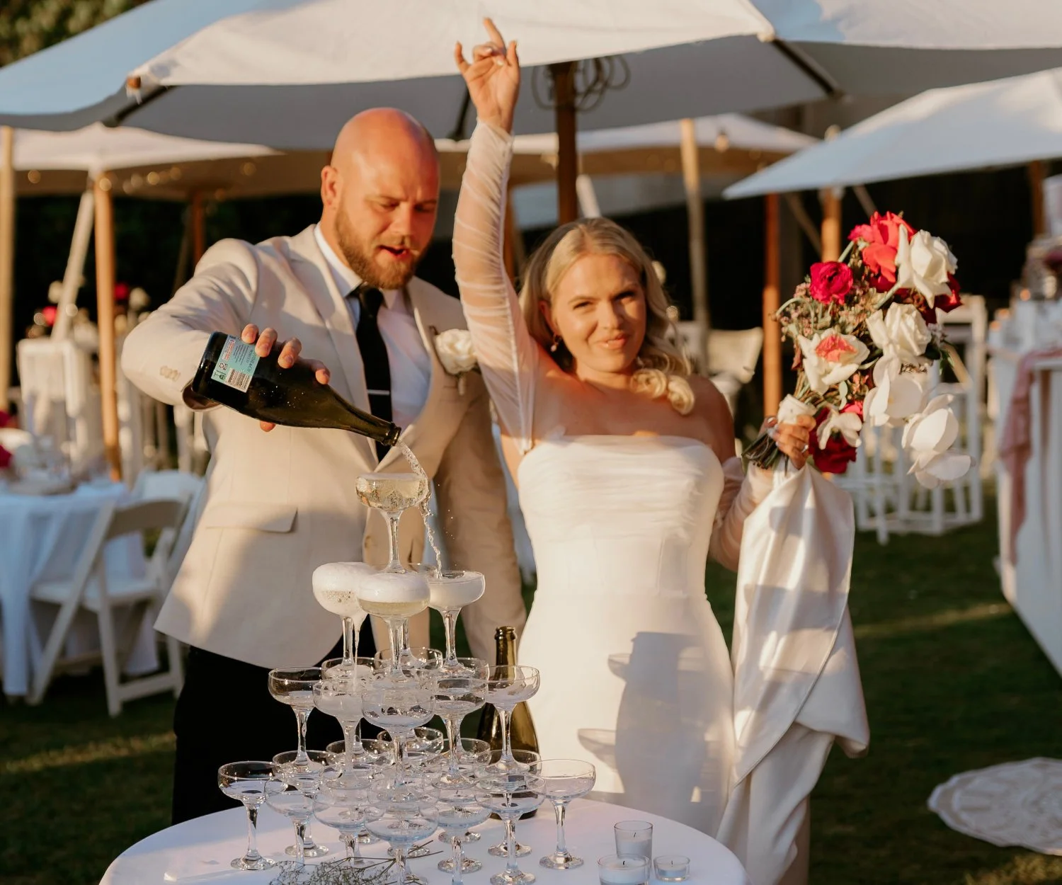 Wedding couple celebrating with a champagne tower