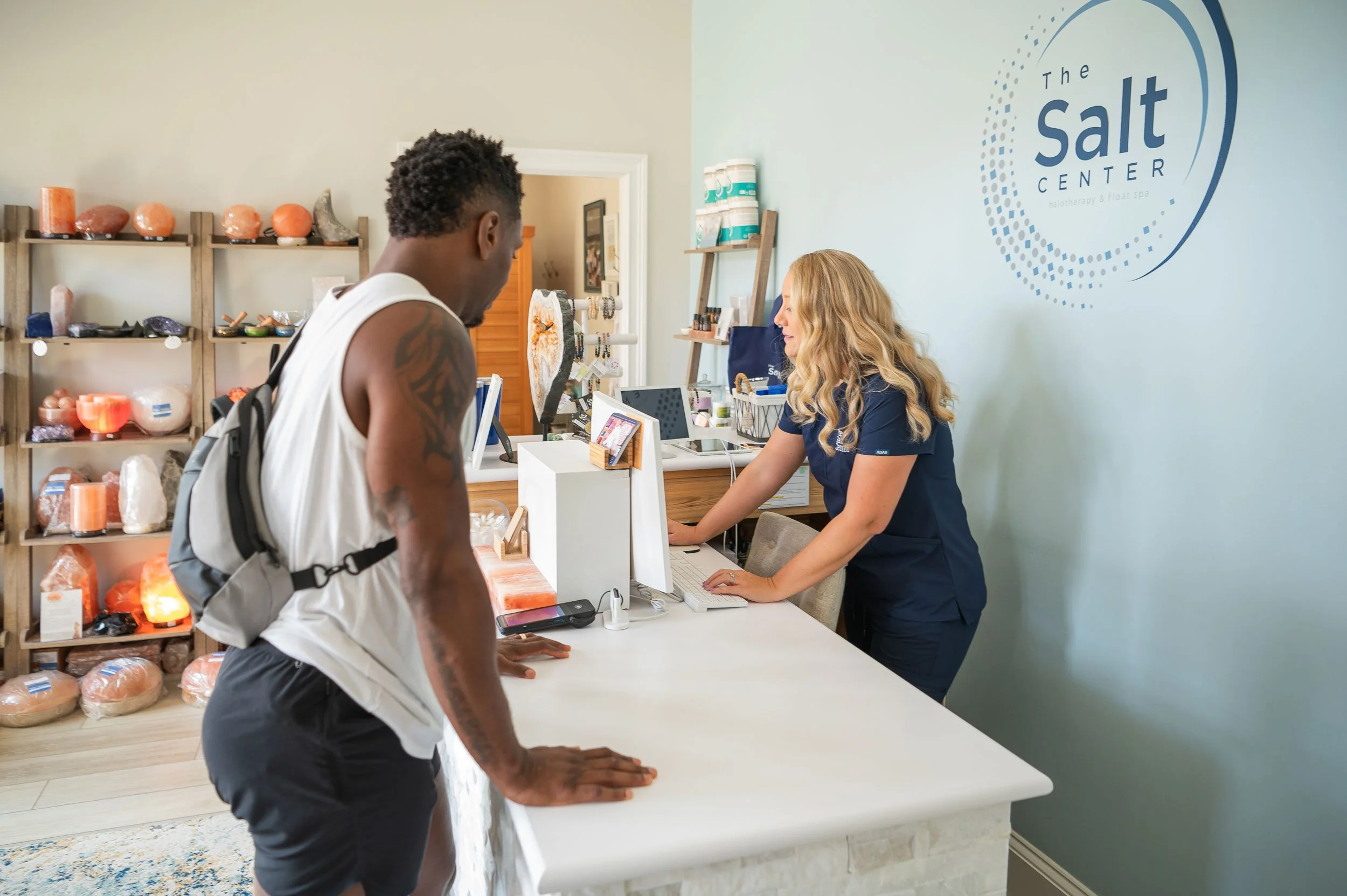 Guest checking in at The Salt Center front desk as part of a corporate wellness visit in Alpharetta, GA