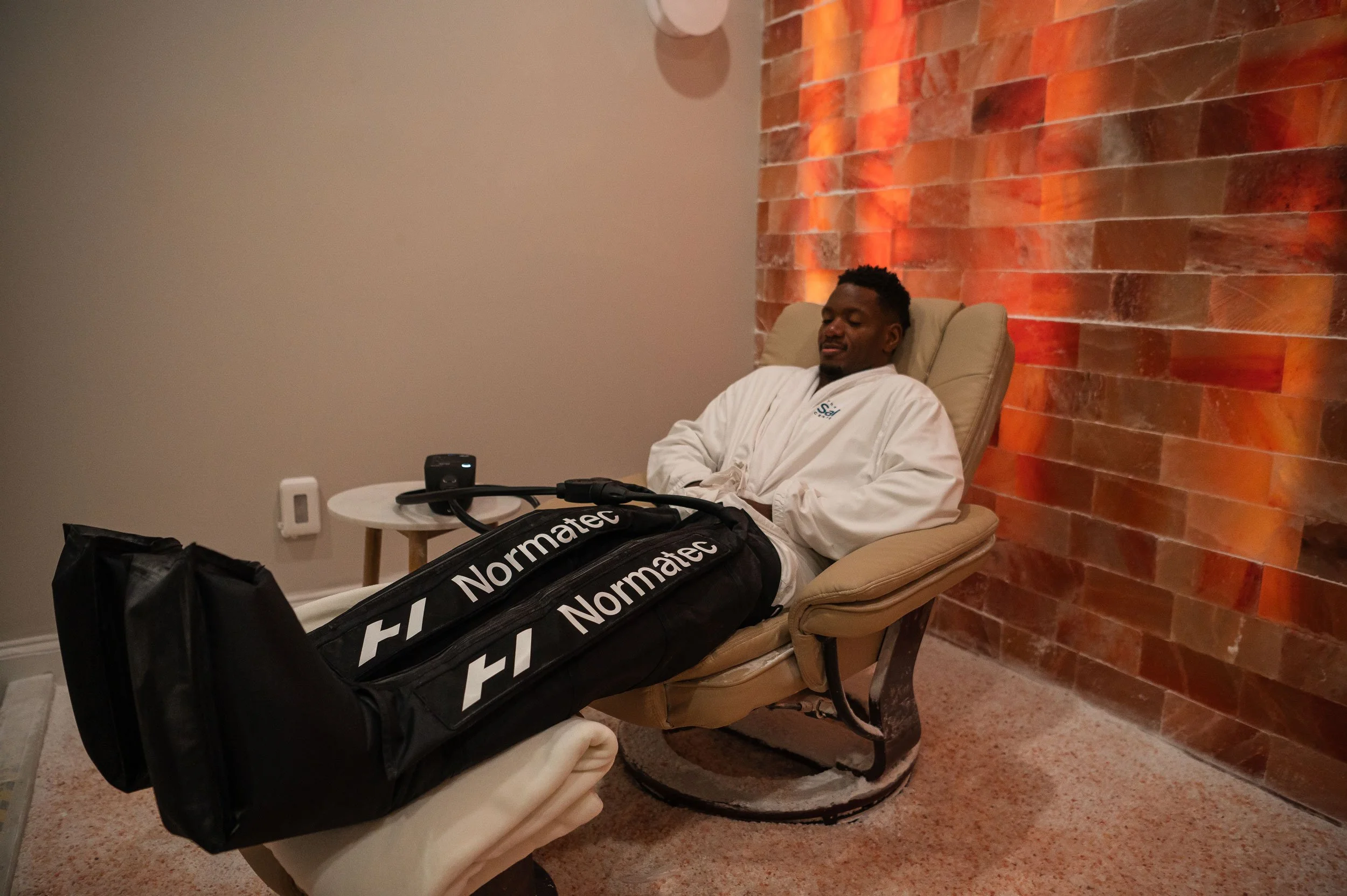 using Normatec leg compression therapy during a Dry Salt Room session at The Salt Center in Alpharetta, GA