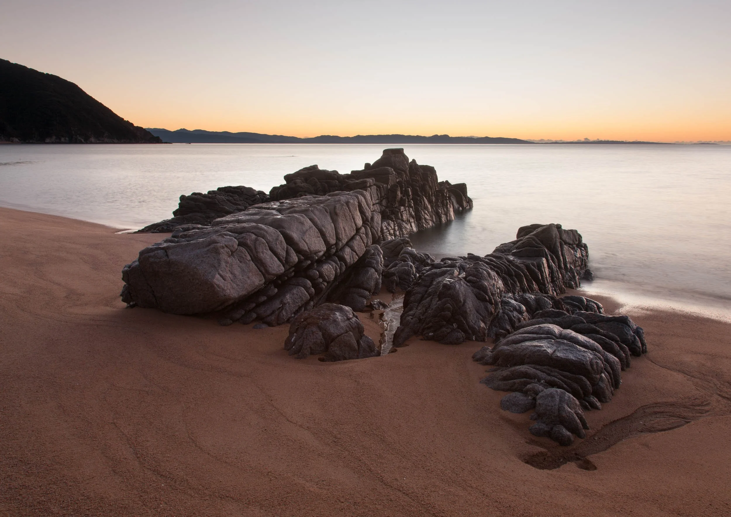 Rock formations on the beach at dusk, Whariwharangi Bay no.1.