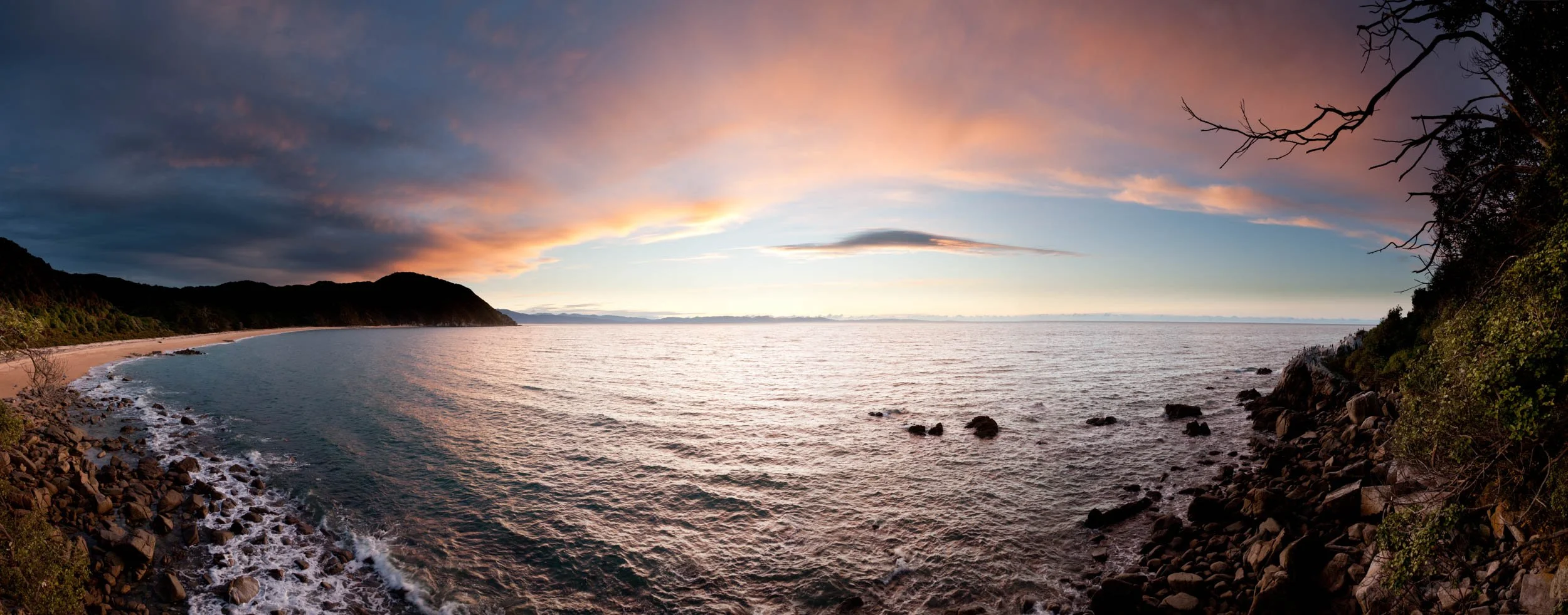 Panoramic view of Whariwharangi Bay at sunset.