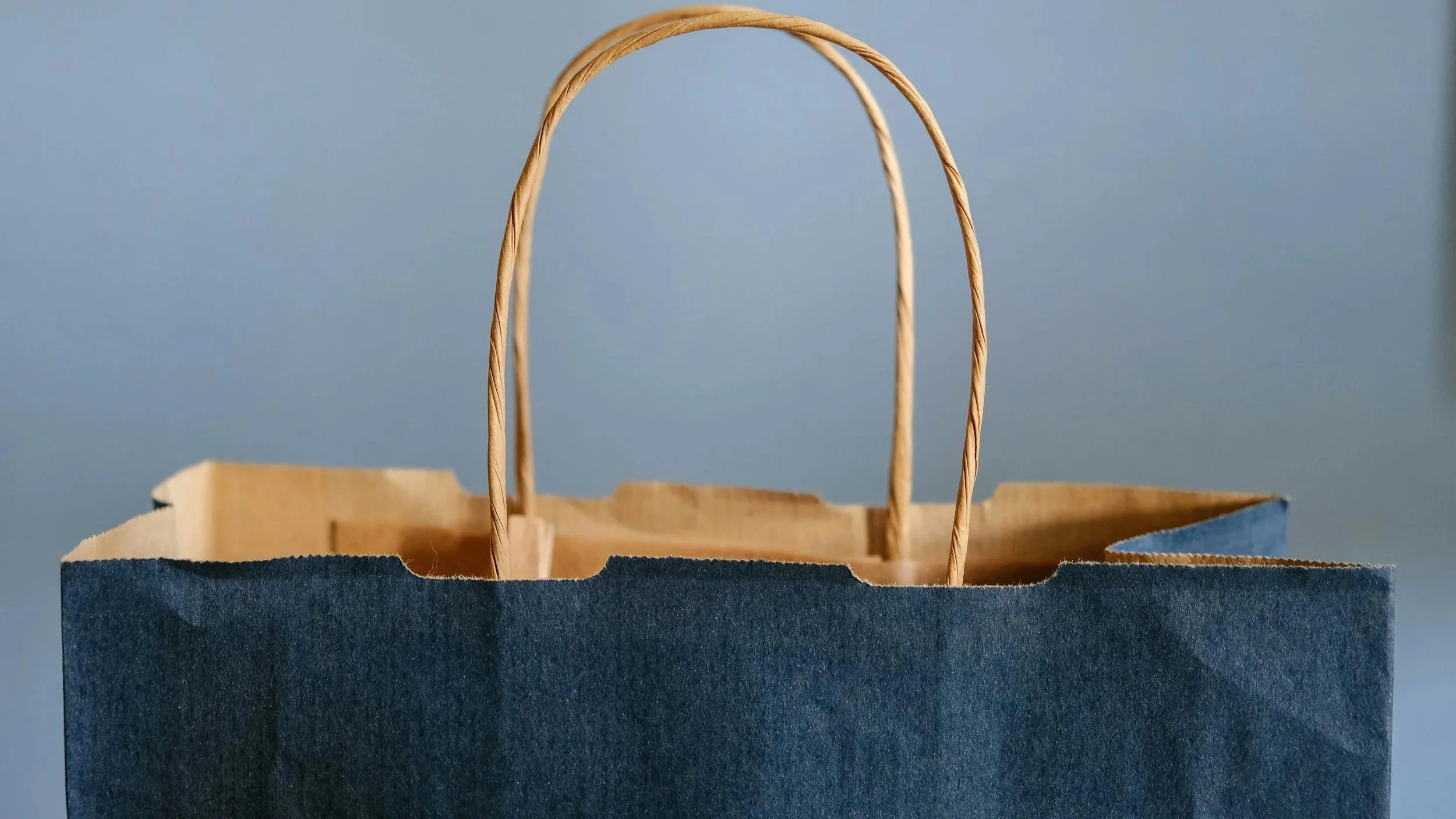 A teal-colored wooden door slightly open, revealing a blurred outdoor scene with greenery in the background.