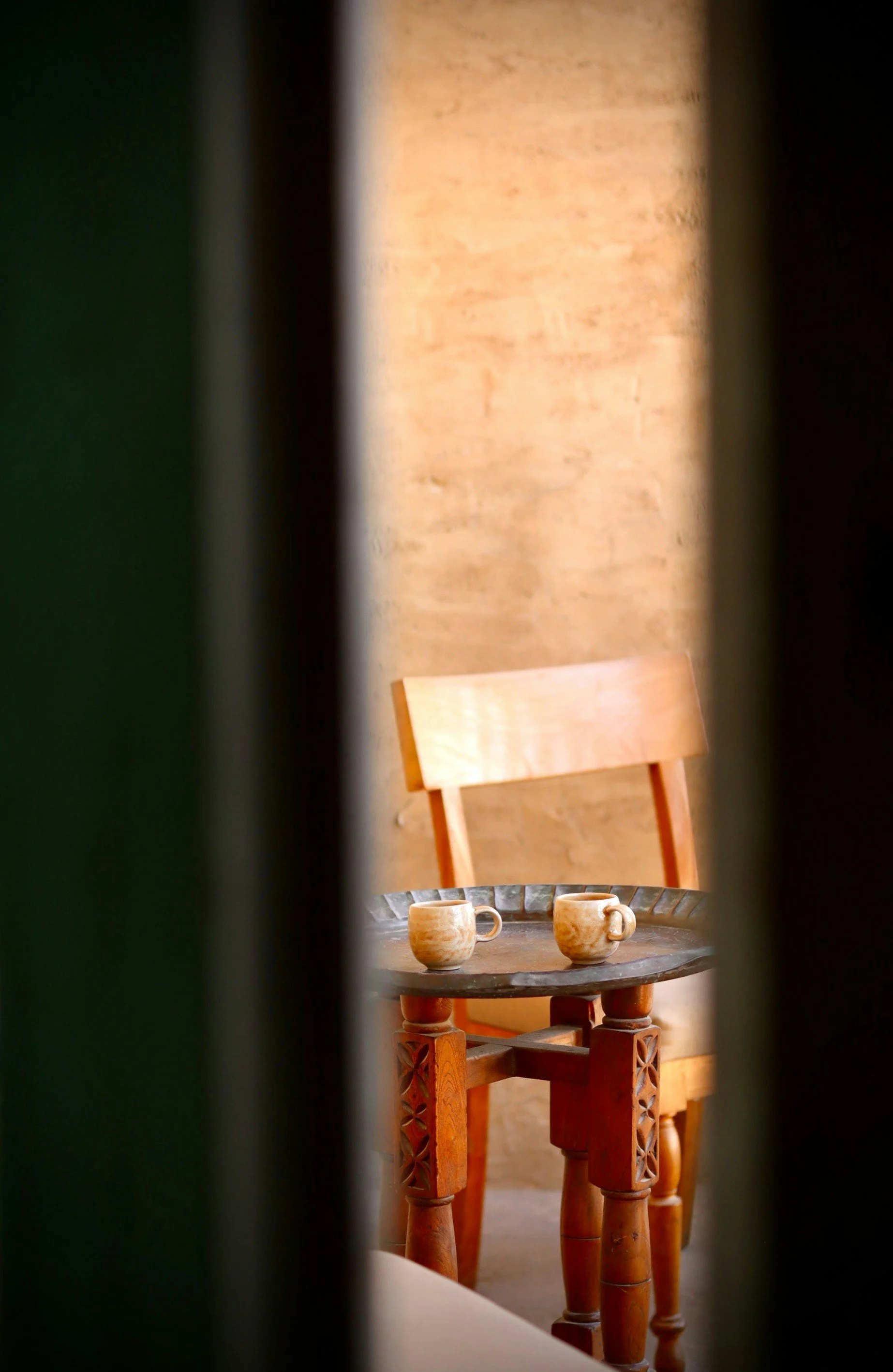 table with two chairs and two coffee mugs