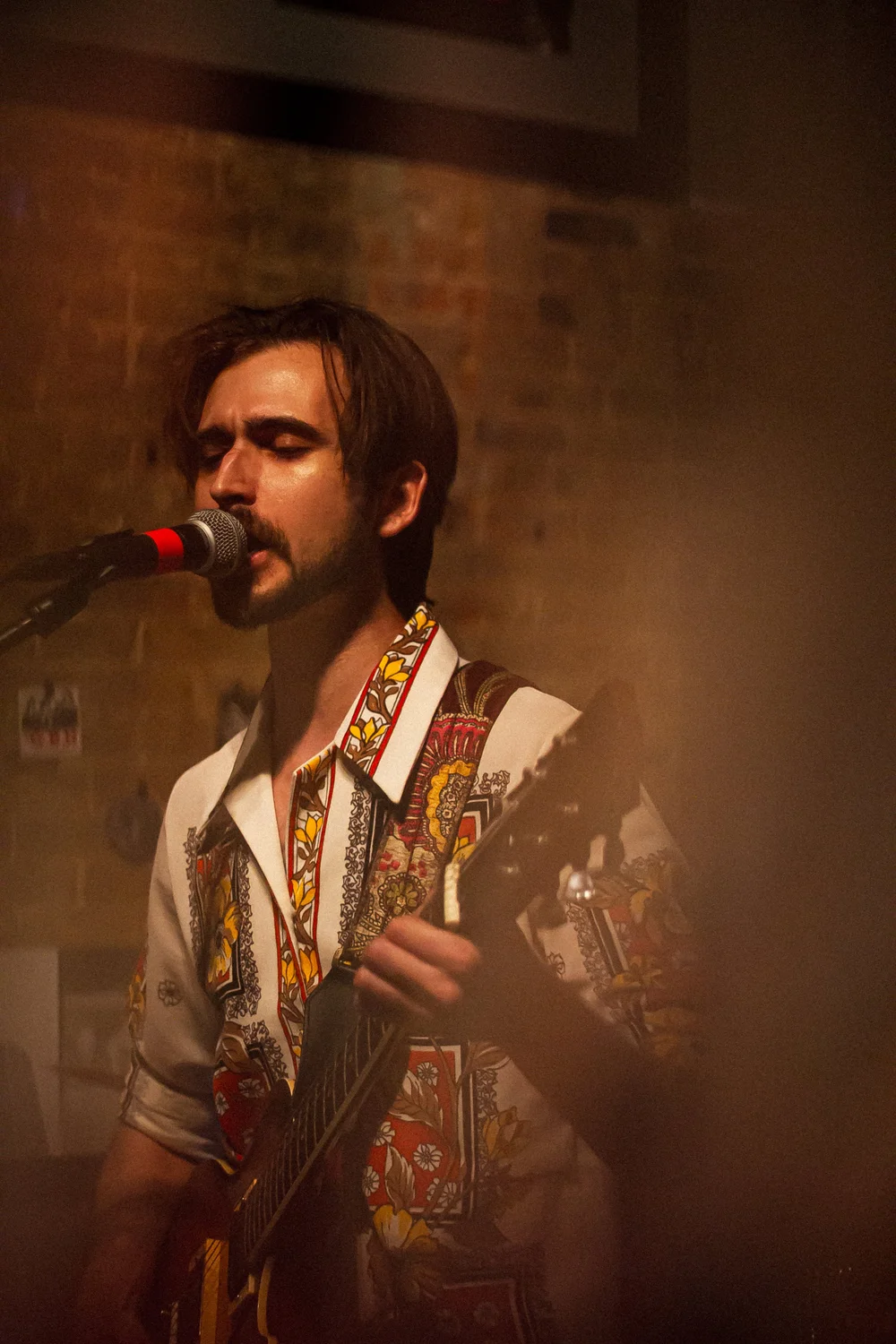 Heartspace Film live music photograph: a singer and guitarist on stage in warm light