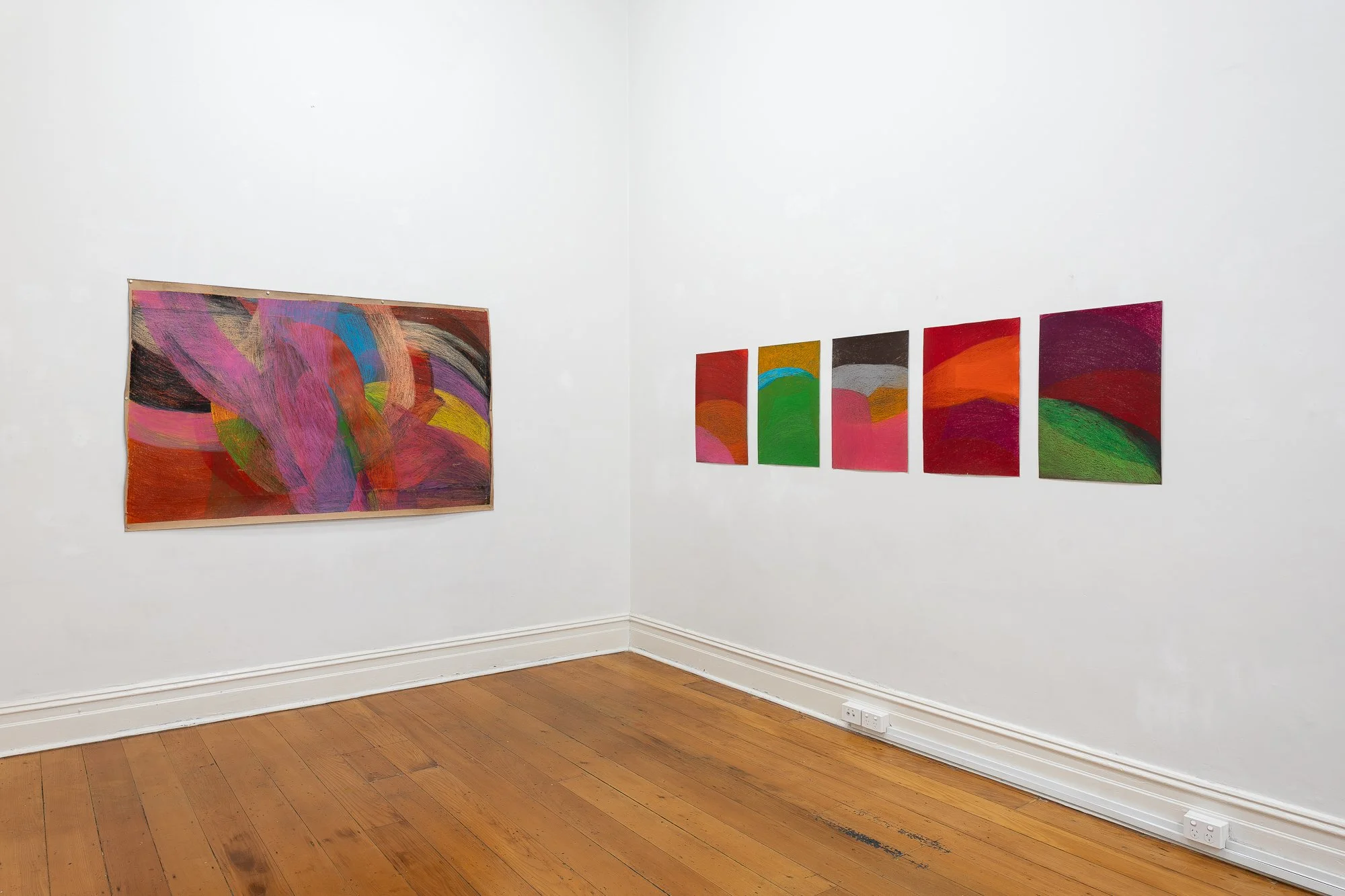 Installation image of  abstract artworks in a white gallery space with wooden floors