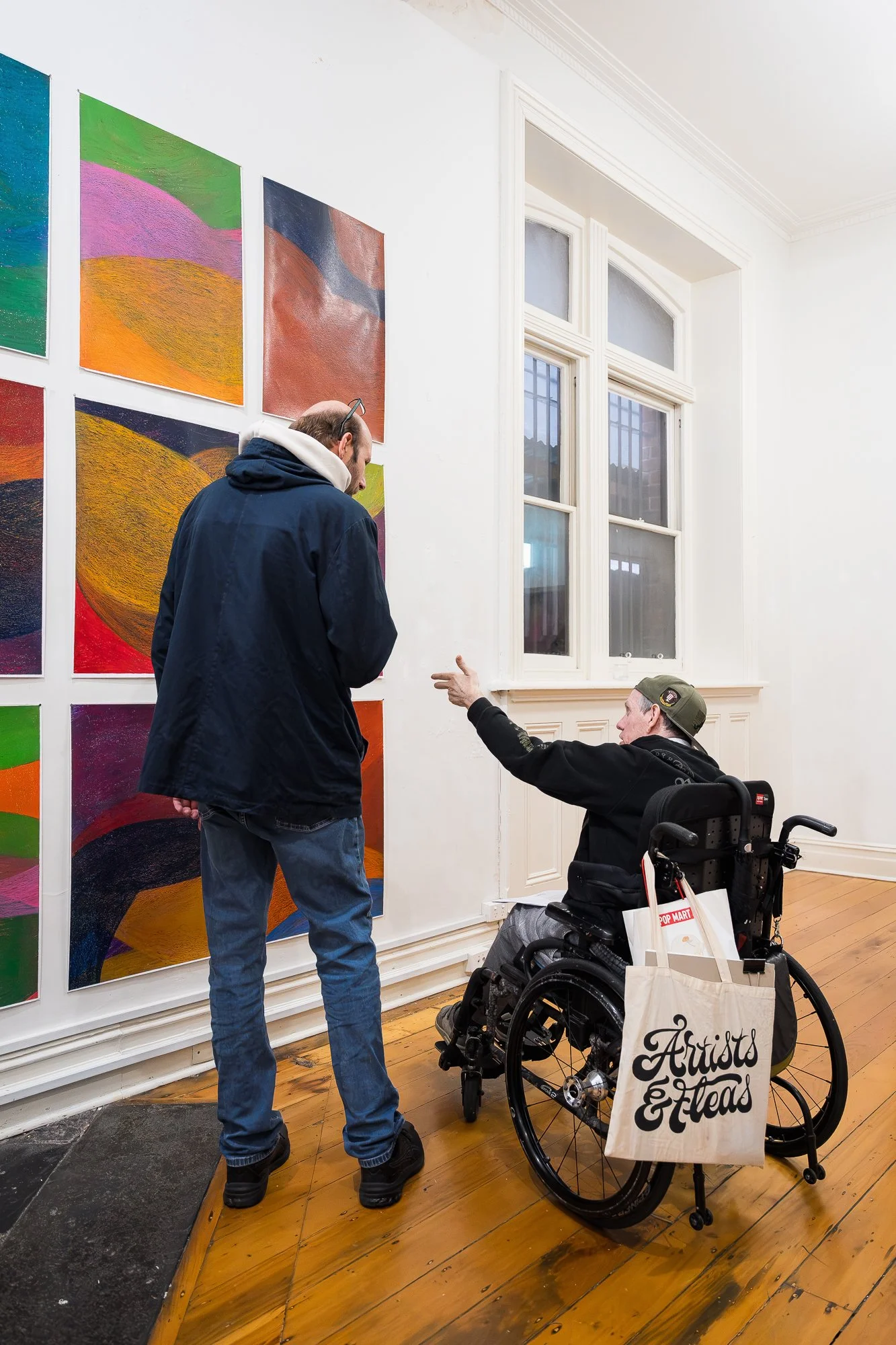 People observing a large abstract drawing installation in an exhibition