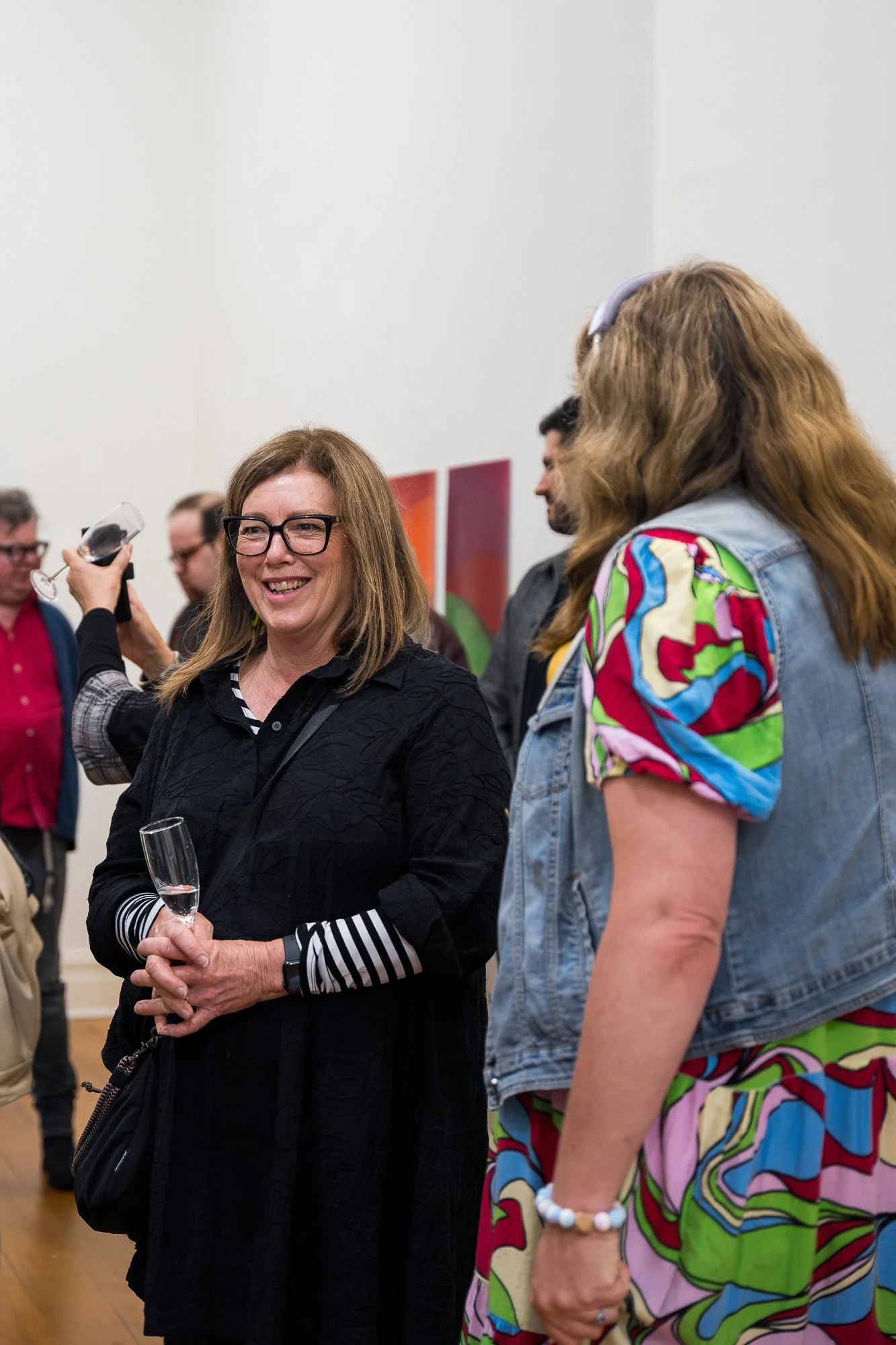 People enjoying an exhibition with colourful artwork