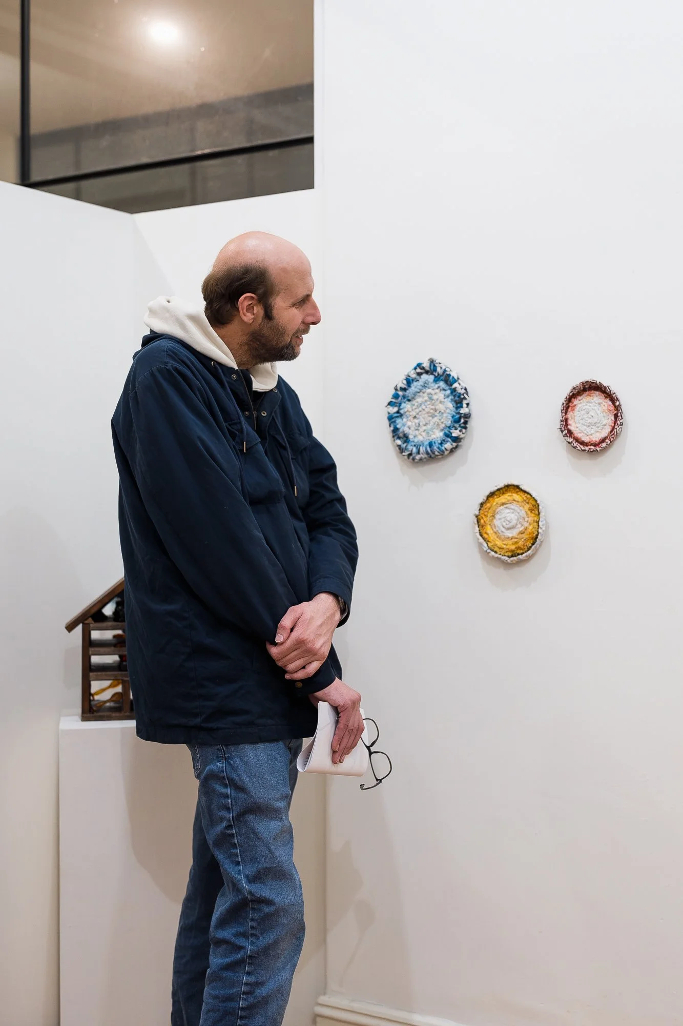 Guest observing textile artworks in an exhibition