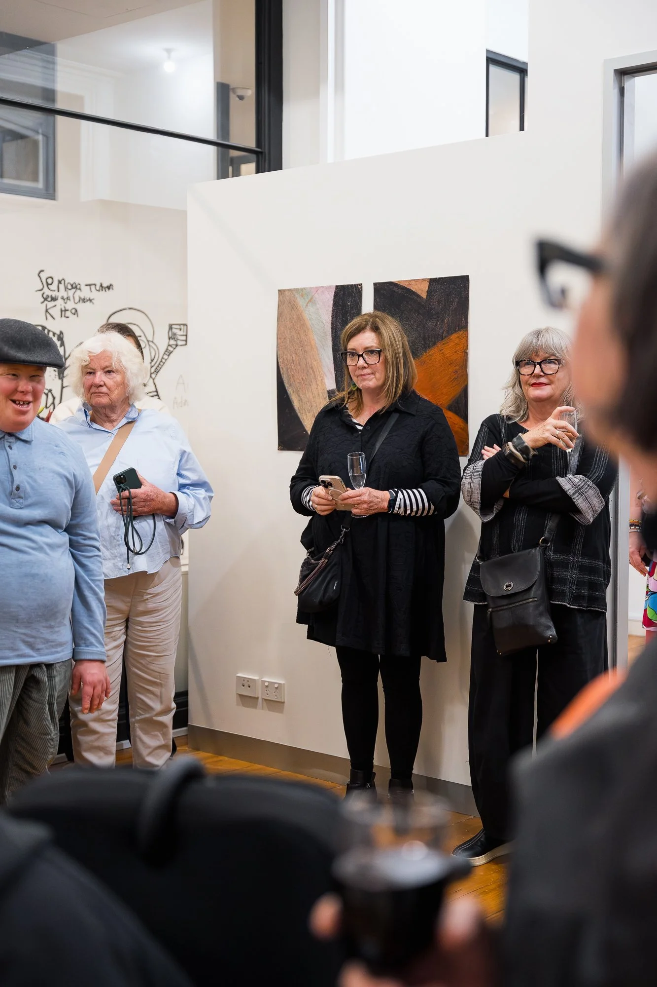 People enjoying an exhibition with colourful artwork