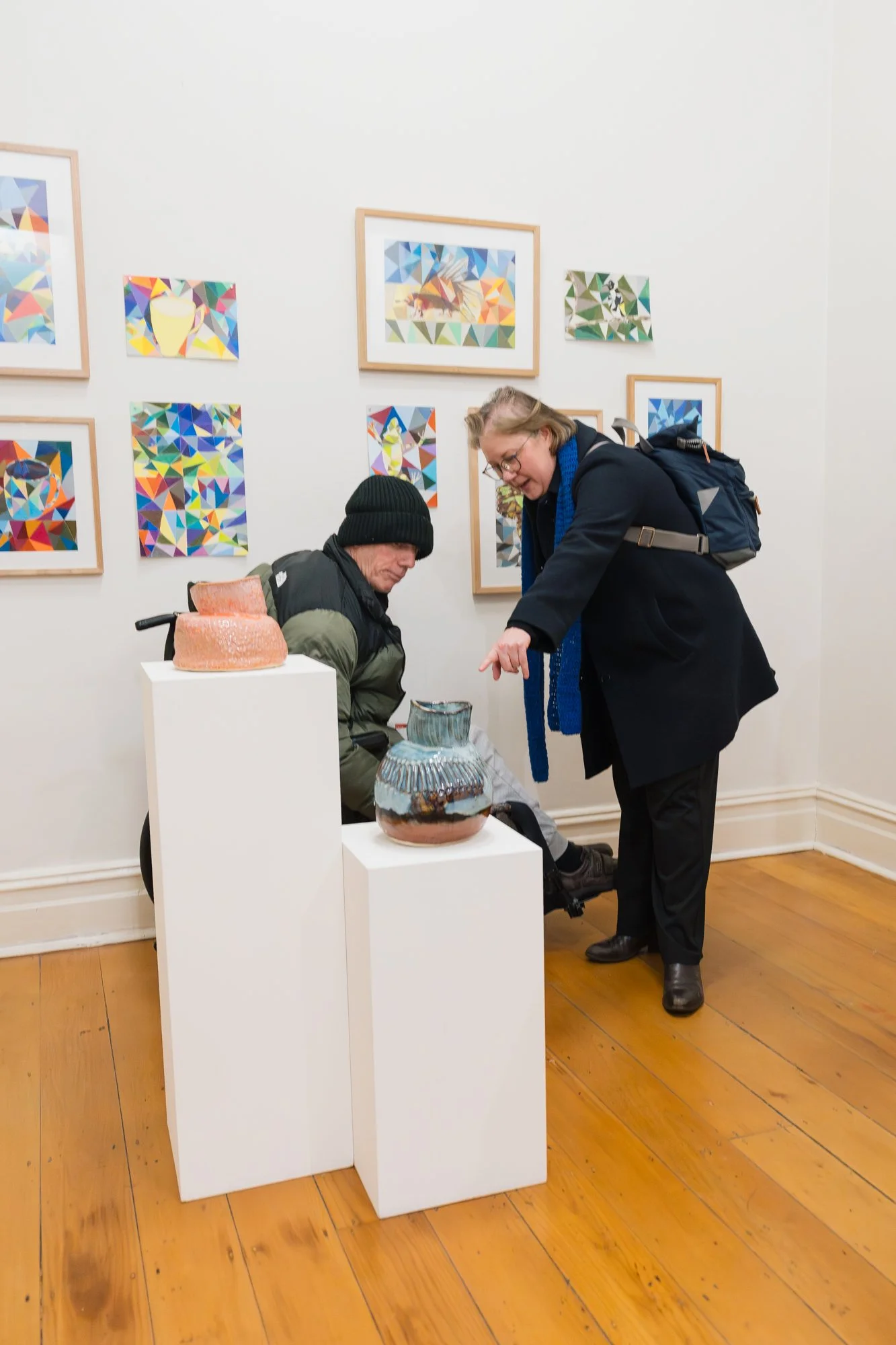 Opening of Convergence 2025 with two people in a light filled gallery space.