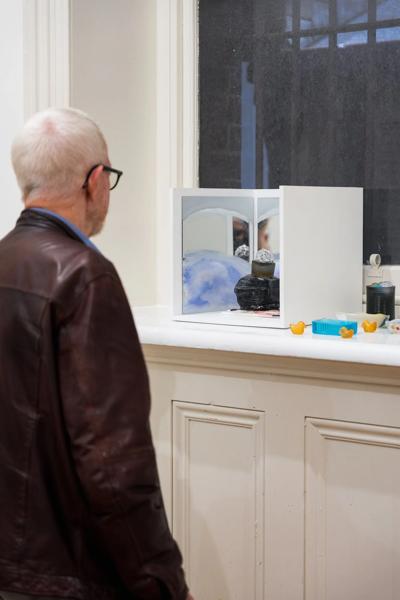 Guest observing glass artworks in an exhibition
