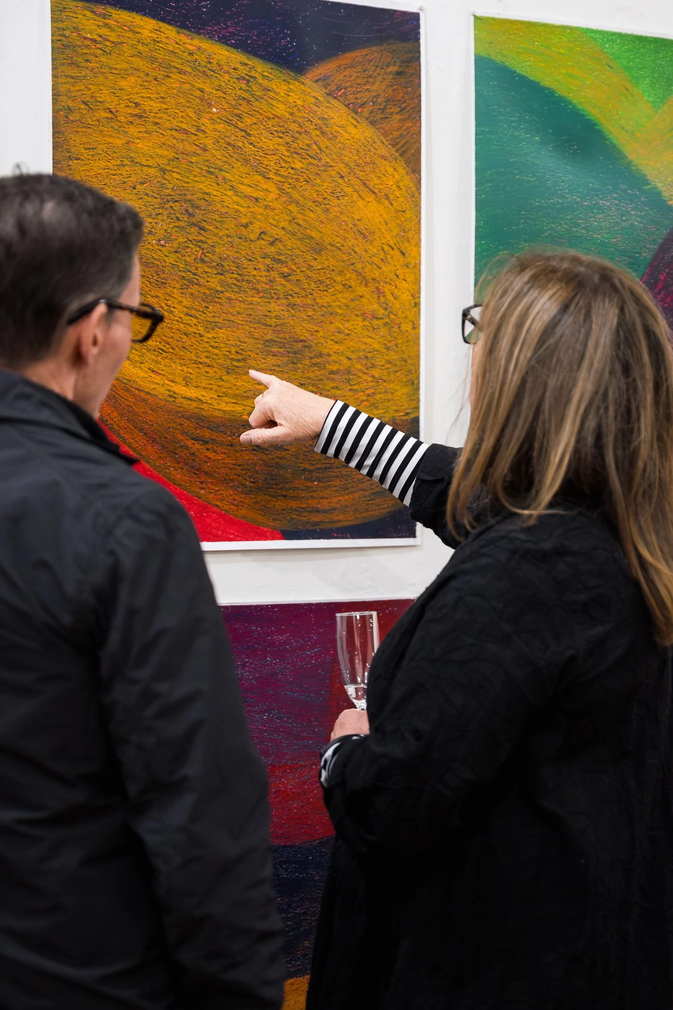 Two people enjoying an exhibition with colourful artwork