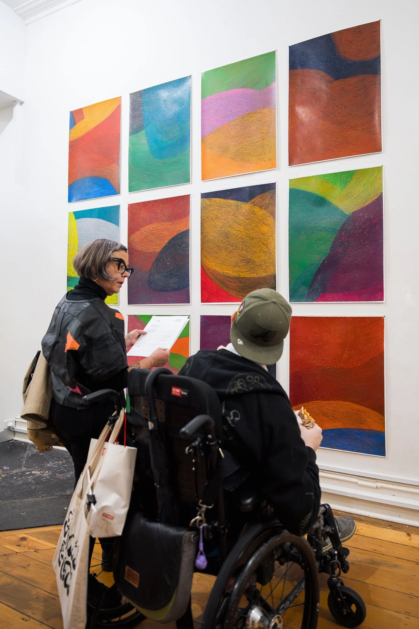 People observing a large abstract drawing installation in an exhibition