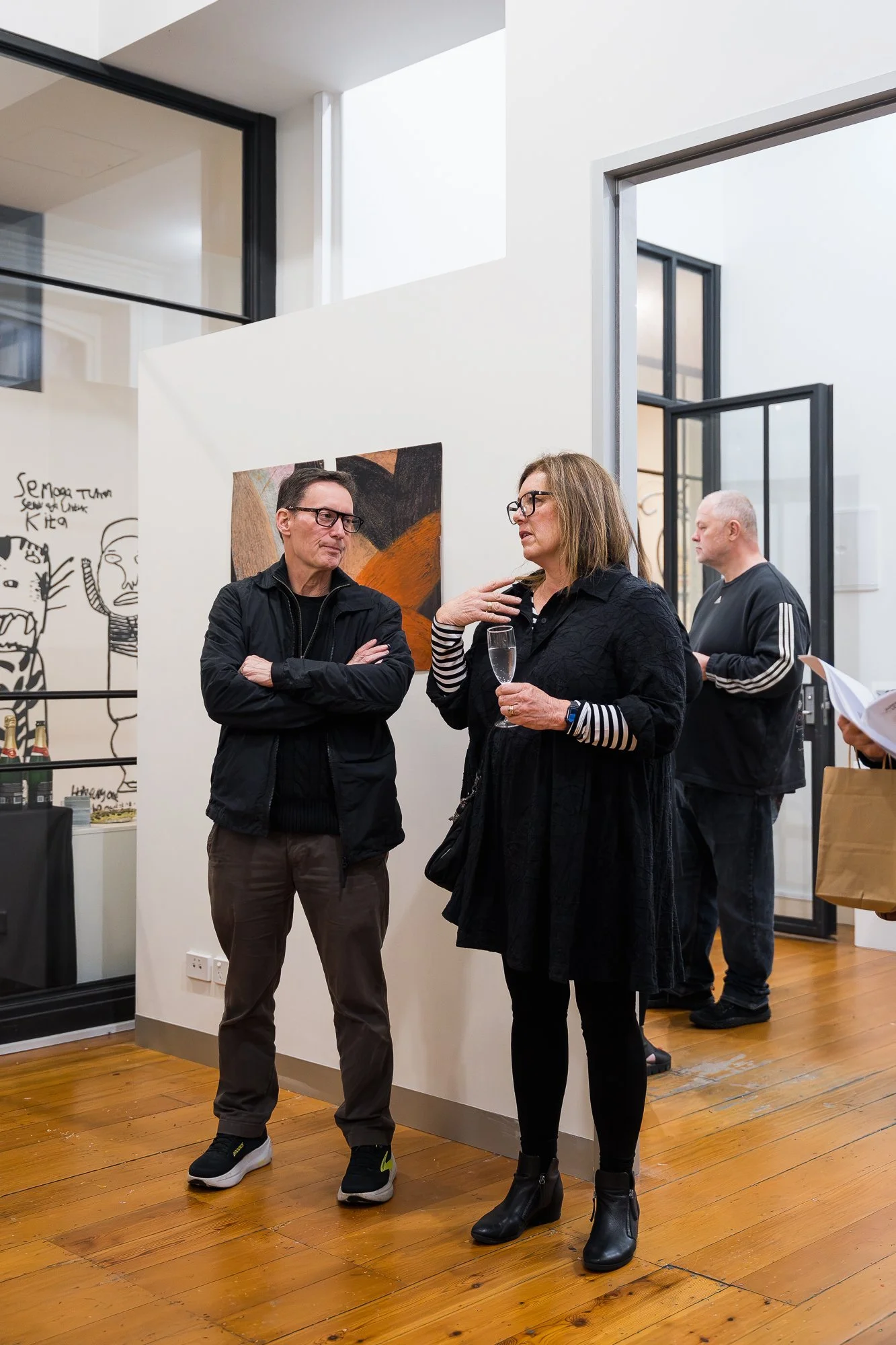 Two people talking amongst artworks at an exhibition