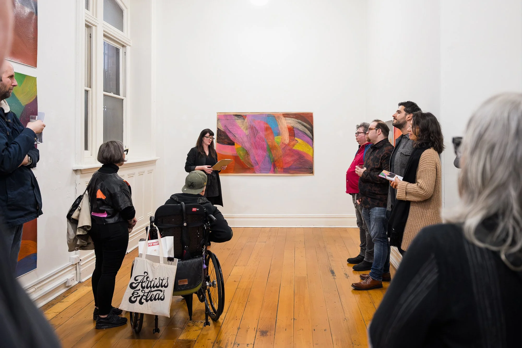 People enjoying an exhibition with colourful artwork