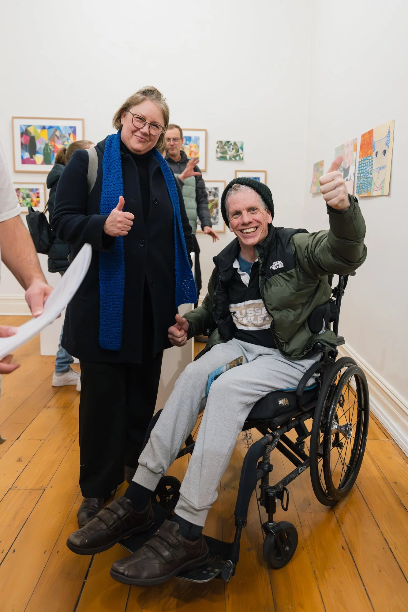 Opening of Convergence 2025 with two people in a light filled gallery space.