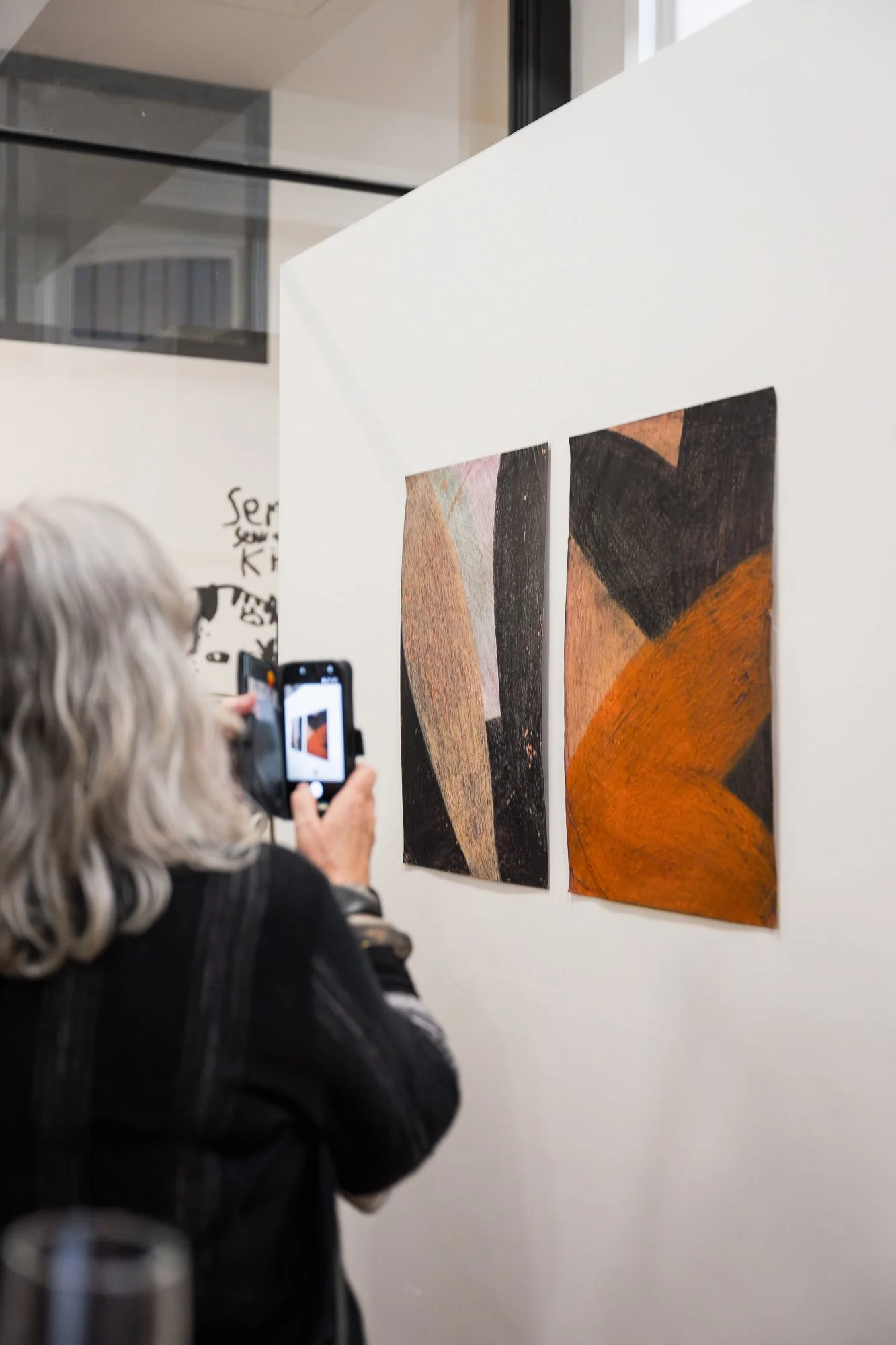 Person photographing an abstract artwork with their smart phone