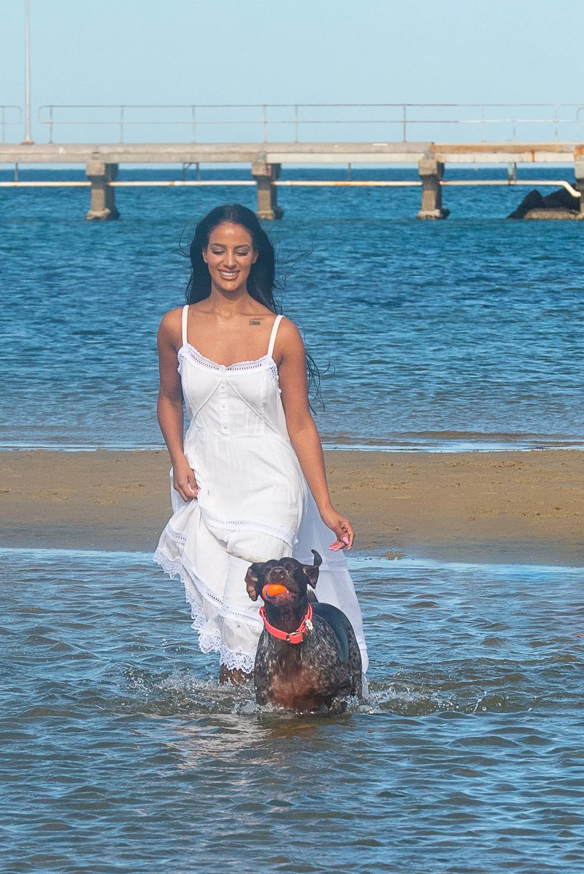 Woman walking with her dog along a beach during a lifestyle photography session in Victoria.
