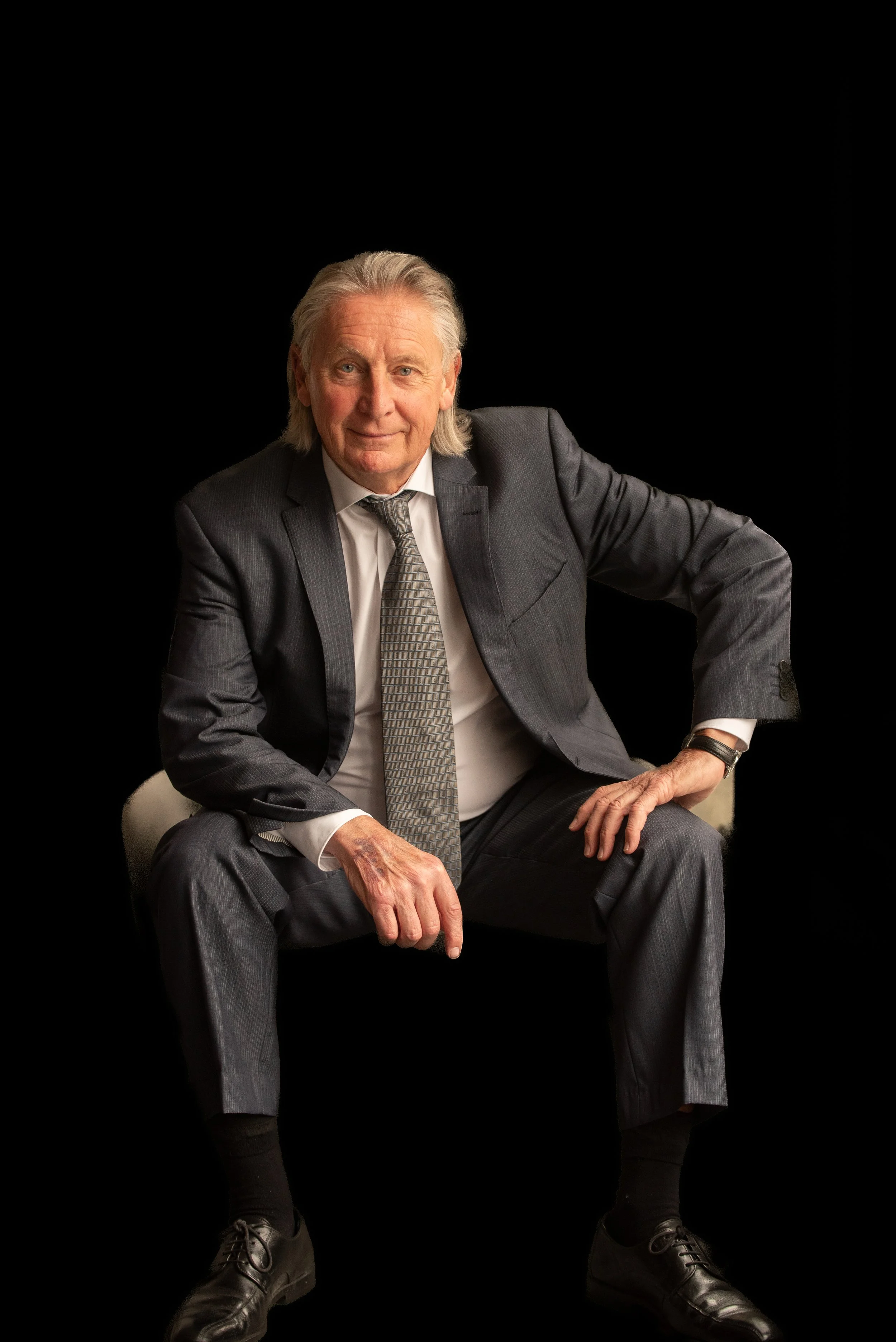 CEO sitting in chair black background