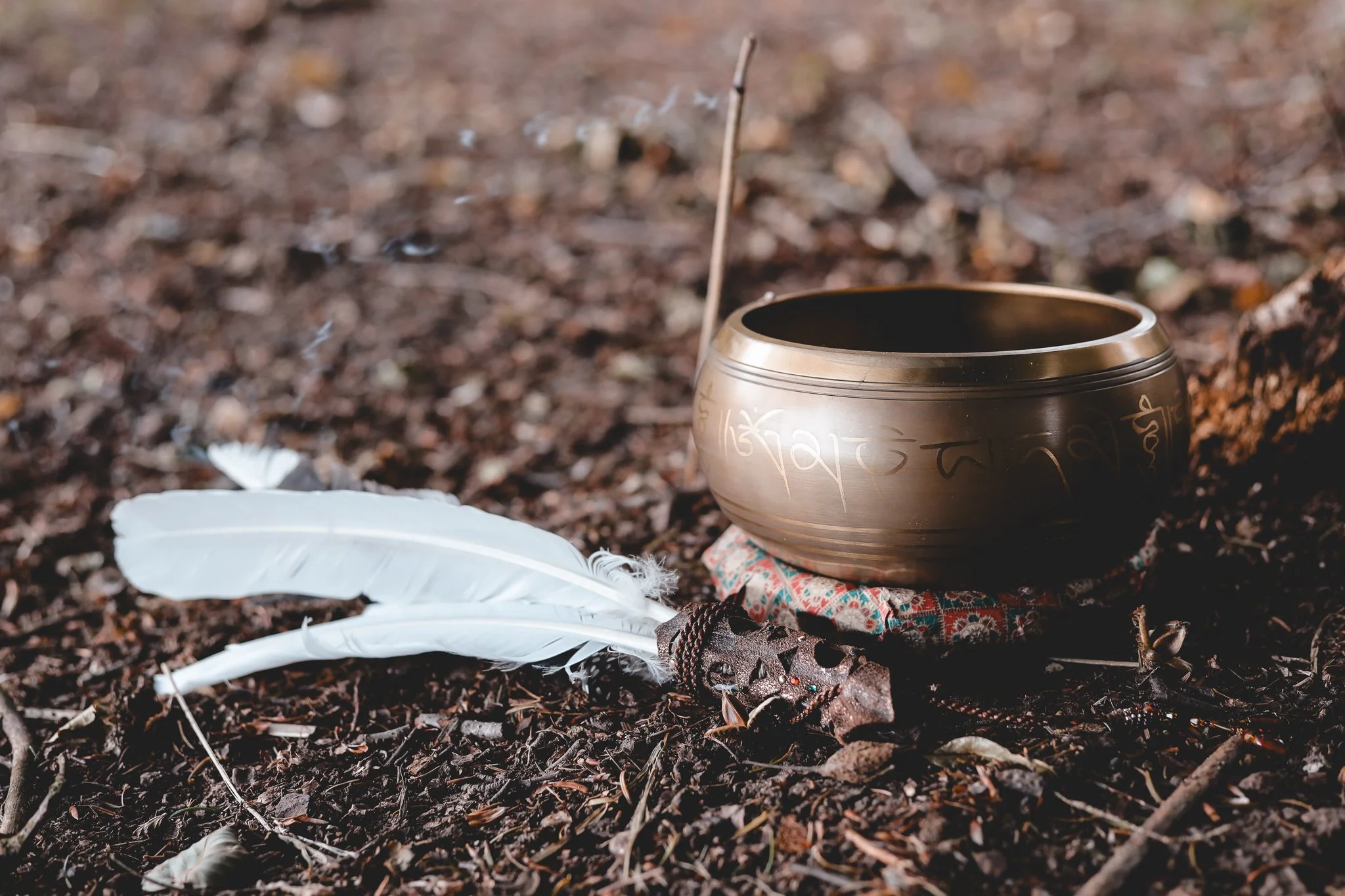 Klangschale und Federn auf natürlichem Hintergrund