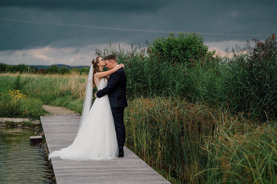 Der Himmel wird dunkel.
Der Wind streicht durchs Schilf.
Alles wirkt ein bisschen dramatischer als geplant.

Aber manchmal passt genau das.

Ihr steht da auf dem Steg,
mitten in dieser weiten Landschaft,
und alles andere r&uuml;ckt f&uuml;r einen Mom