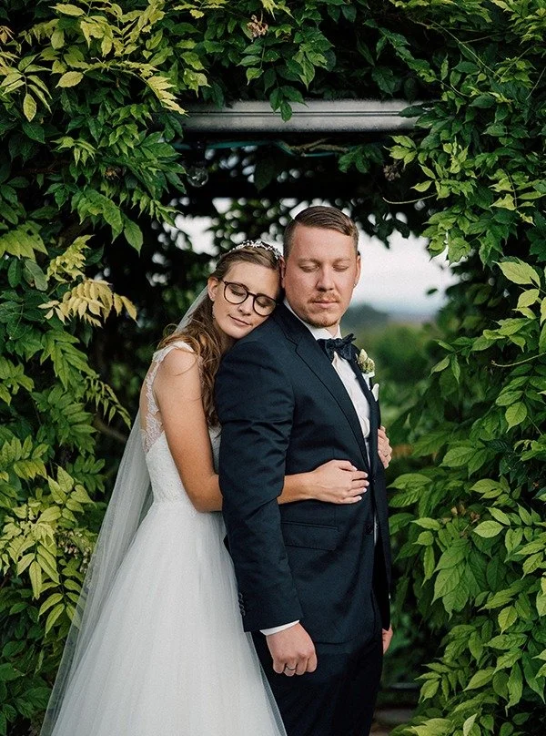 Zwischen all den Momenten eines Hochzeitstages gibt es diese kleinen Pausen.

Augenblicke, in denen man sich einfach anlehnt. Den Kopf kurz auf die Schulter legt und tief durchatmet.

Nicht f&uuml;r die G&auml;ste.
Nicht f&uuml;r ein Foto.

Sondern e