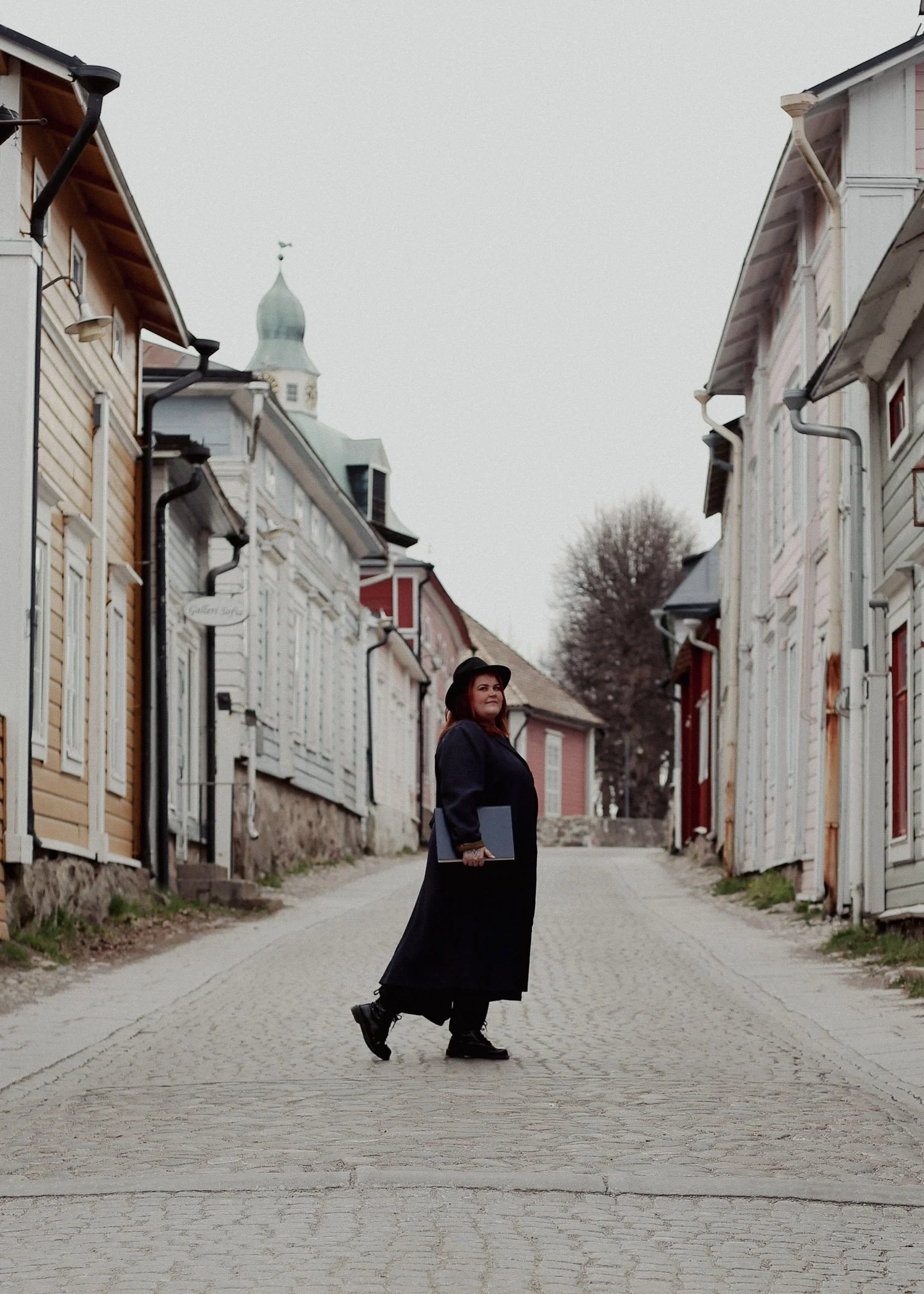 Bea Mattila kävelee kadun yli Porvoon Vanhassa kaupungissa.