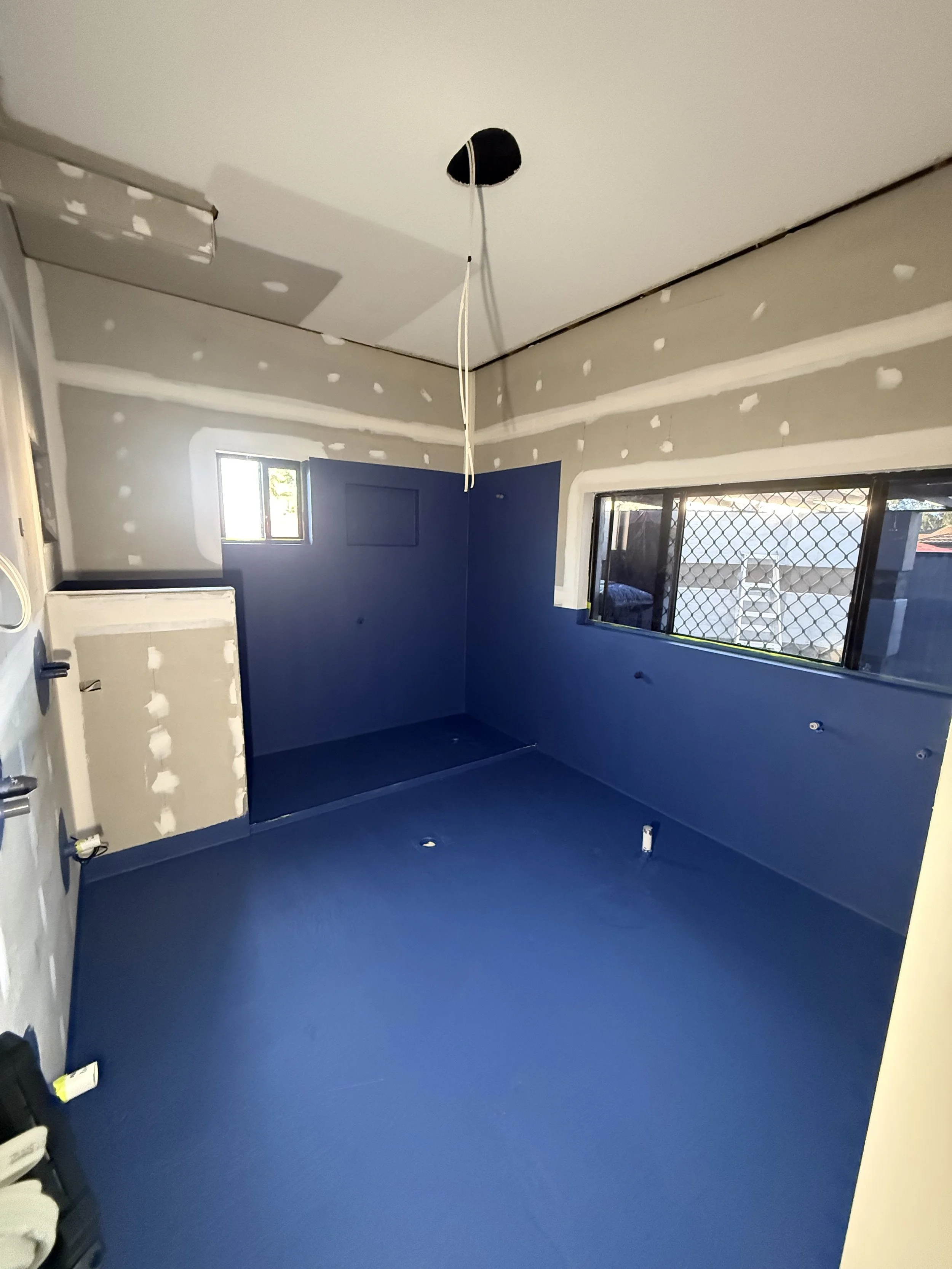 Wellington Point bathroom renovation during construction, showing waterproofing preparation before tiling and fit-off.