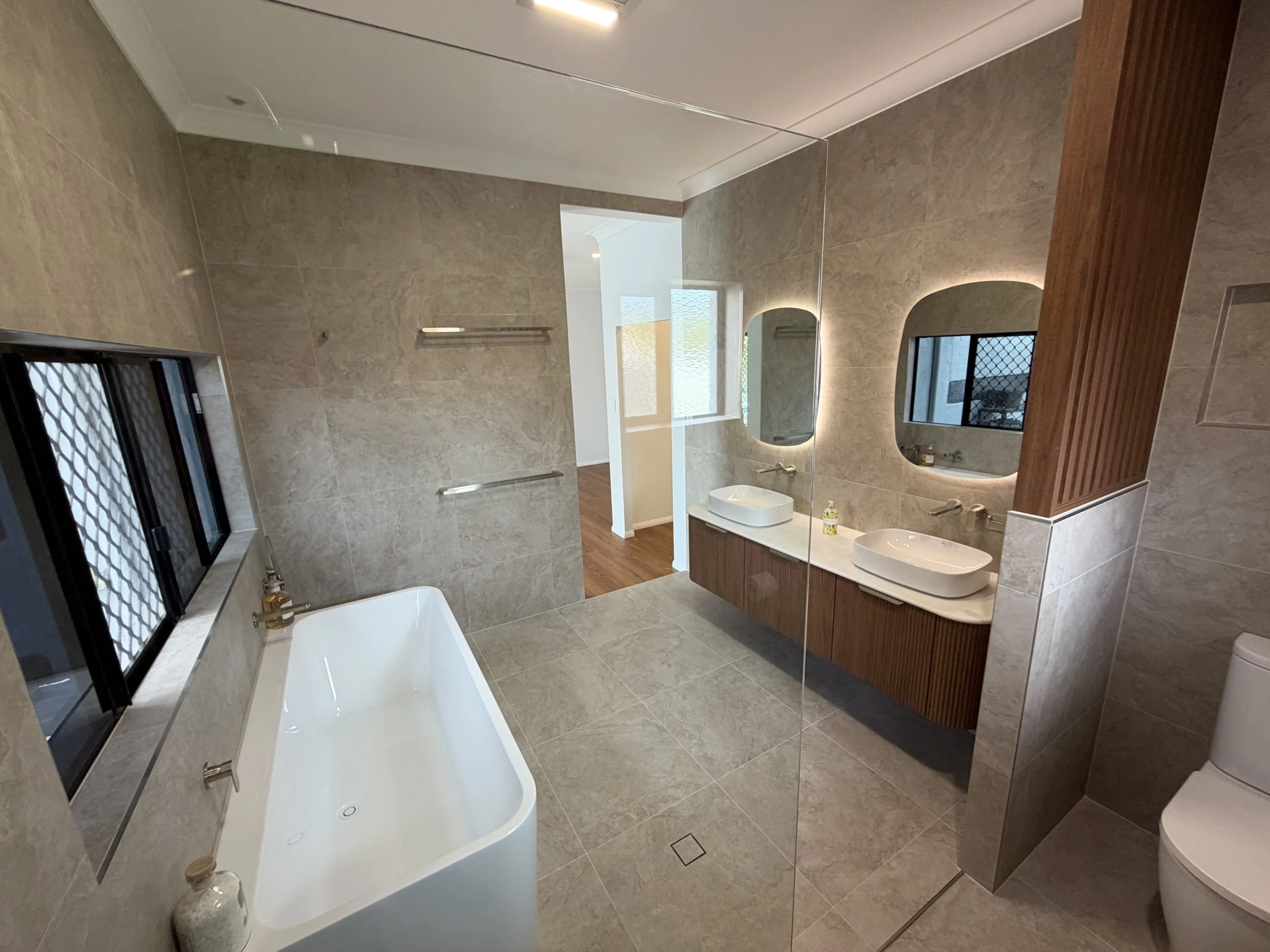 Spacious Wellington Point ensuite renovation featuring a freestanding Posh Domaine bathtub and custom walnut double vanity.