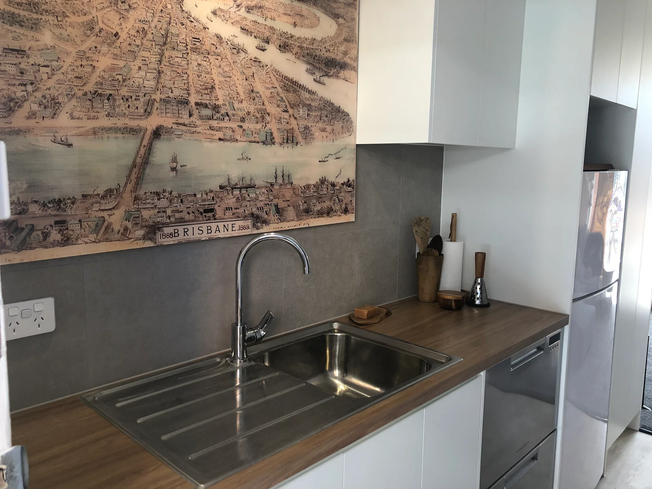 Modern studio apartment kitchenette renovation with timber benchtop, custom cabinetry and timber look flooring in Brisbane