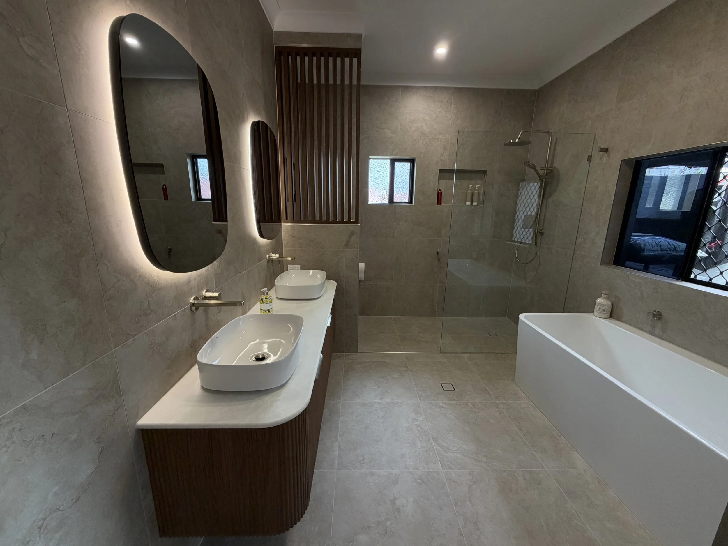 Ensuite bathroom renovation in Wellington Point featuring a freestanding bathtub, double vanity and contemporary stone-look tiles.