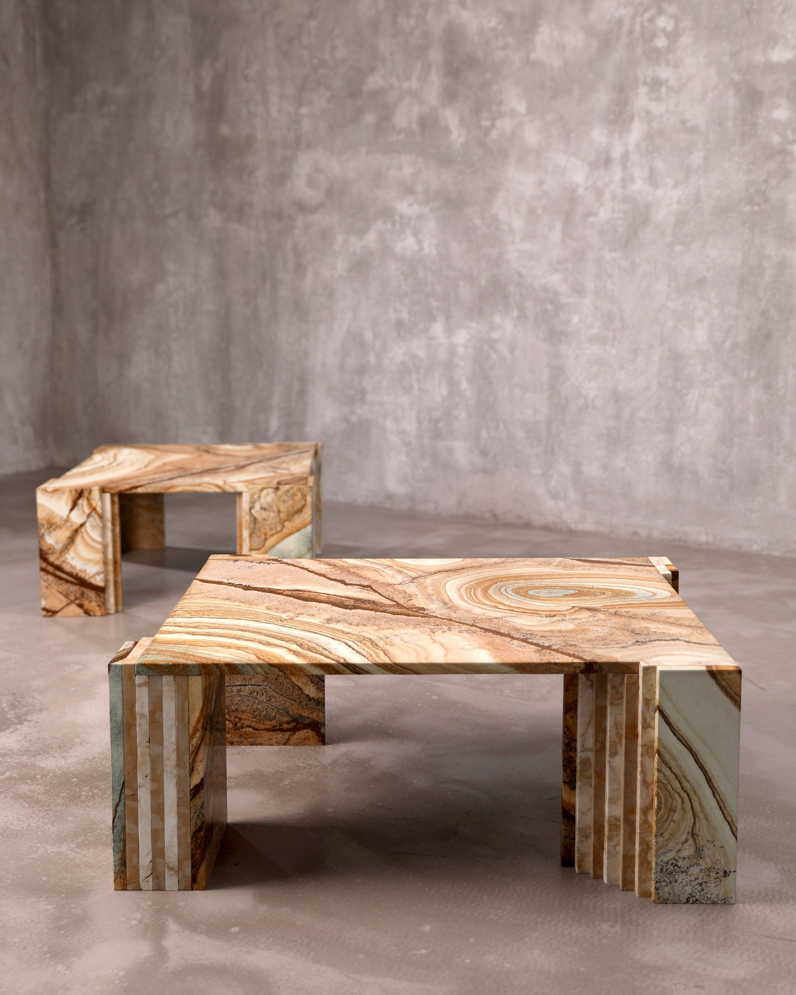 Shown together, the pair of Terraforma low tables reveal subtle contrasts in form and detailing.
One features layered stone legs meeting at a book-matched corner, where the veins flow seamlessly across the mitred joint &mdash; a quiet gesture that hi