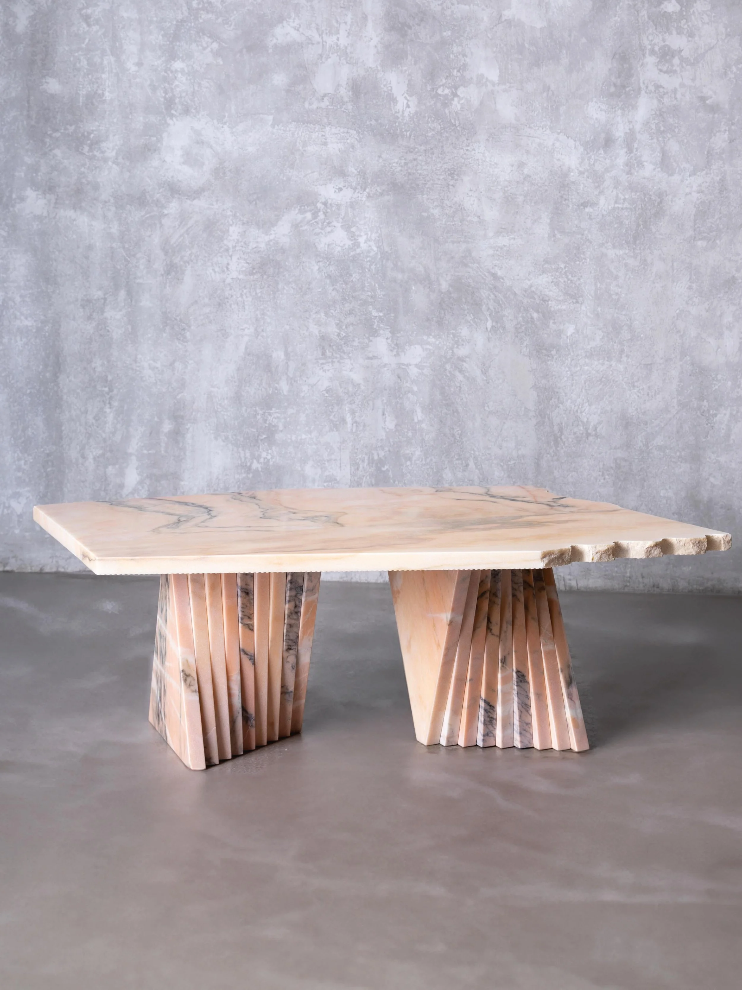 Kaleidoscope outdoor coffee table.

A composition of reclaimed Rosa Aurora marble - where sculptural geometry meets the unpredictability of natural stone.

The faceted triangular bases create a shifting play of light and shadow, giving the table a di
