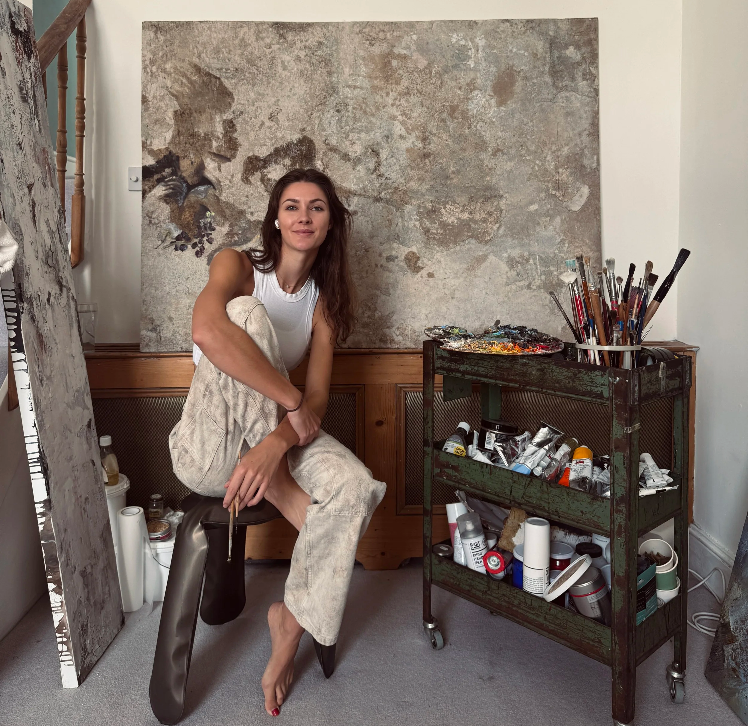 Raine Storey in front of one of her oil paintings
