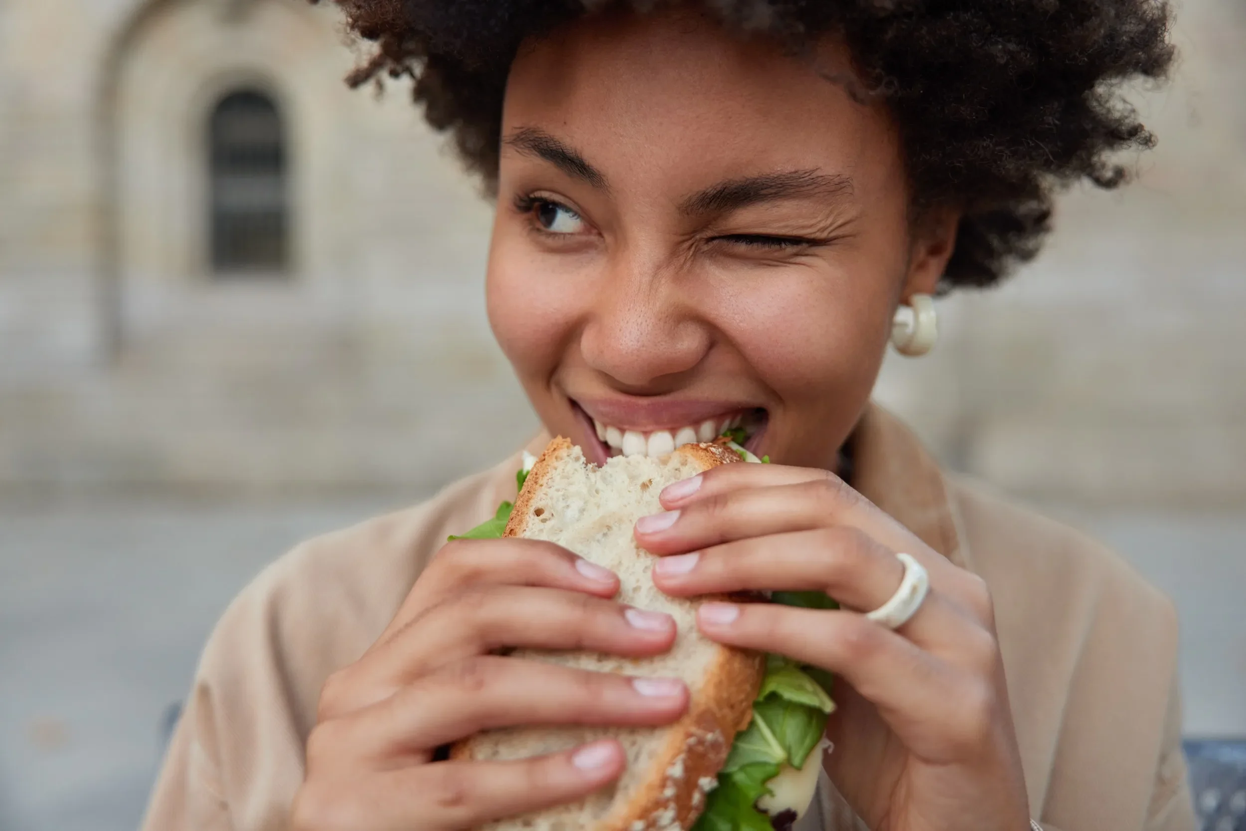 A beautiful woman eating a healthy sandwich.