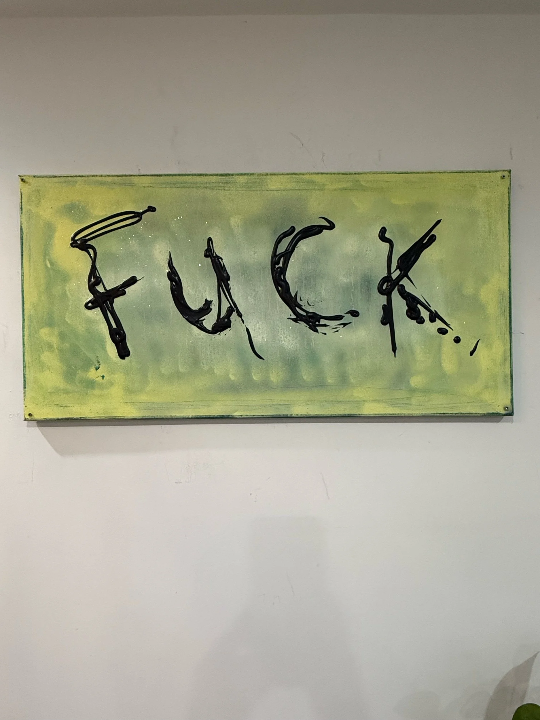 Detail of ESSENTIAL artwork showing expressive hand-painted black lettering on green abstract surface