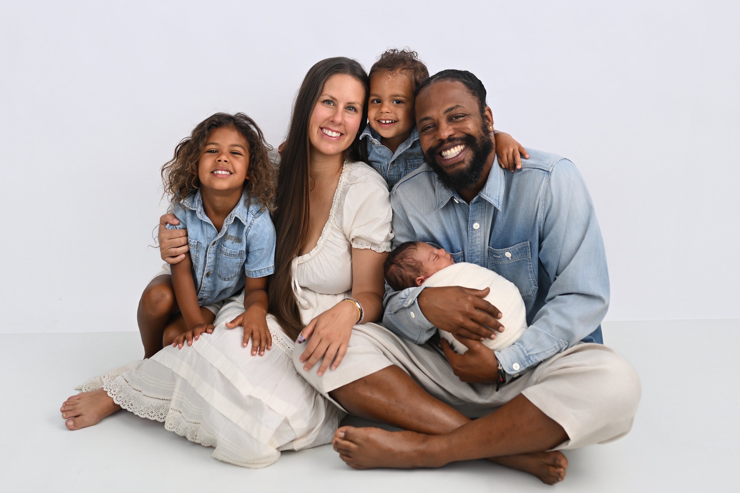 Family holding their newborn baby during a studio photography session at Beachside Portraits in Satellite Beach, Florida