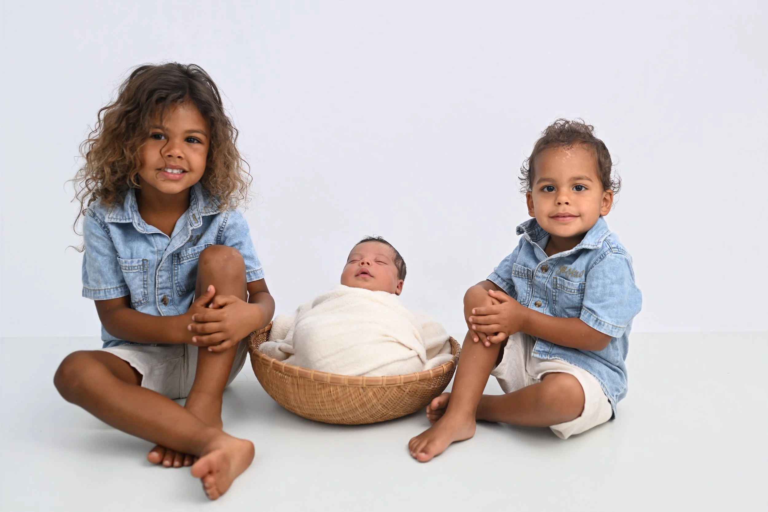 Newborn baby with older sibling during family portrait session