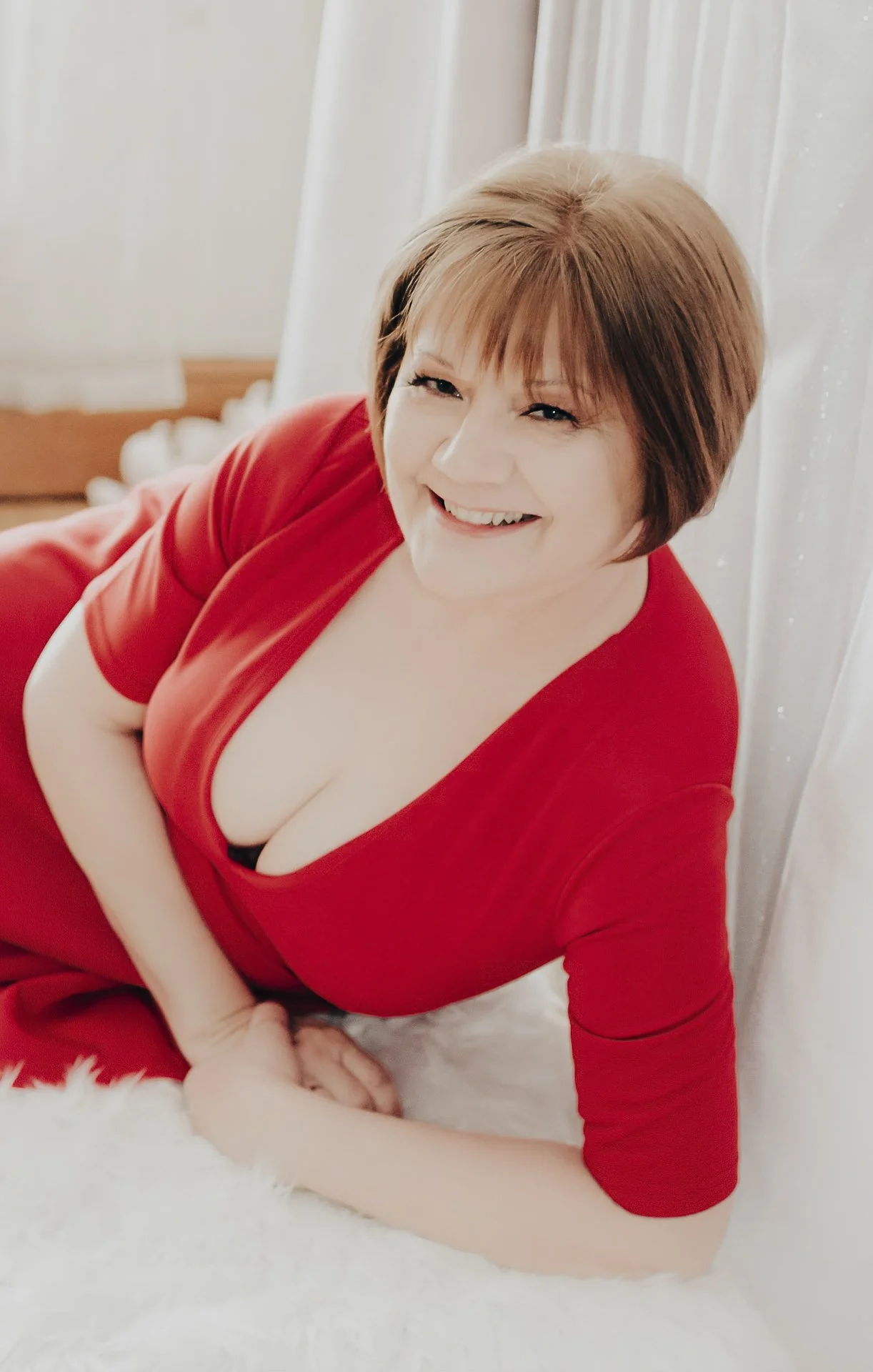 A beautiful portrait of a smiling woman in a red dress.