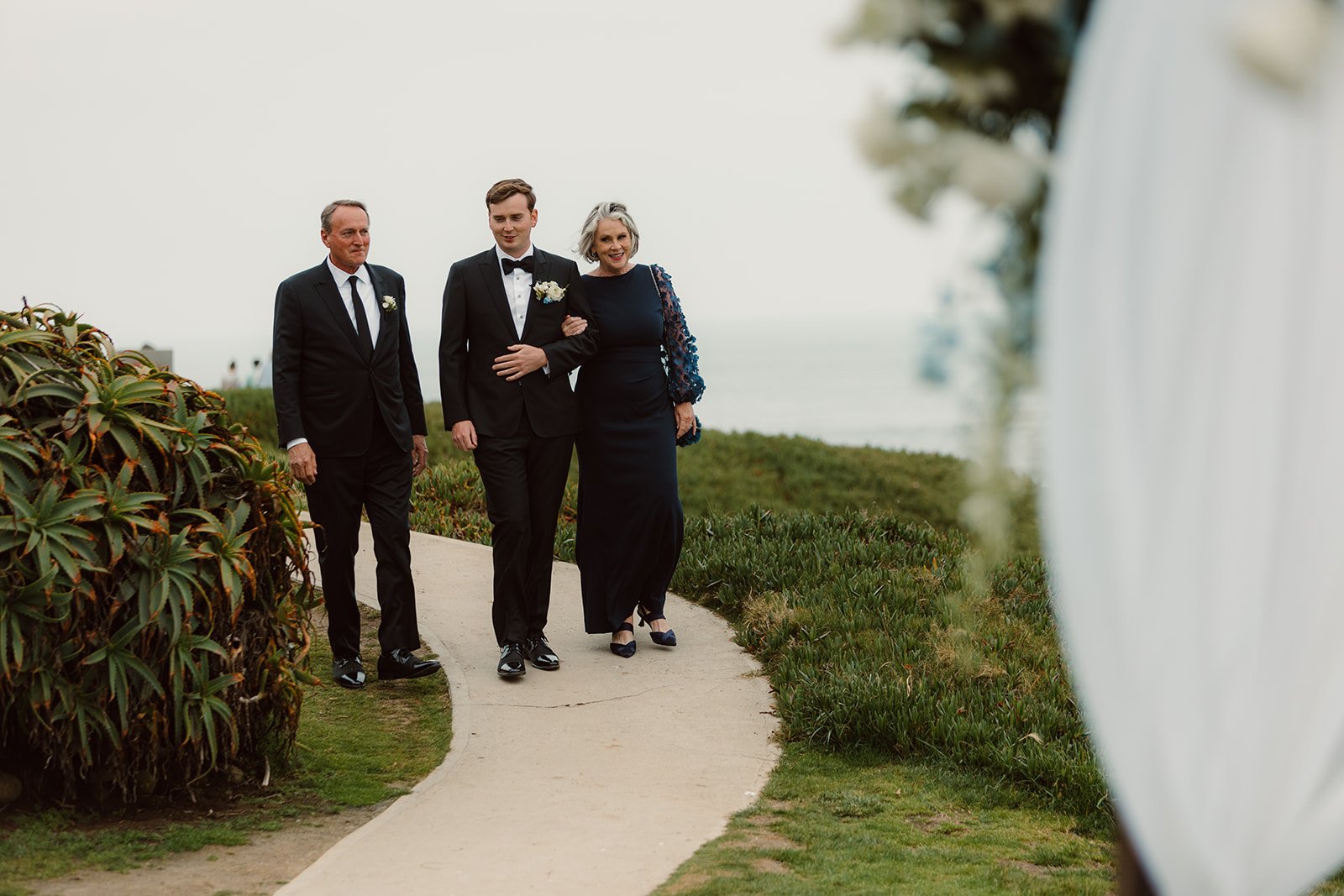 Groom is walking with his parents for his wedding ceremony at the Wedding Bowl in La Jolla.