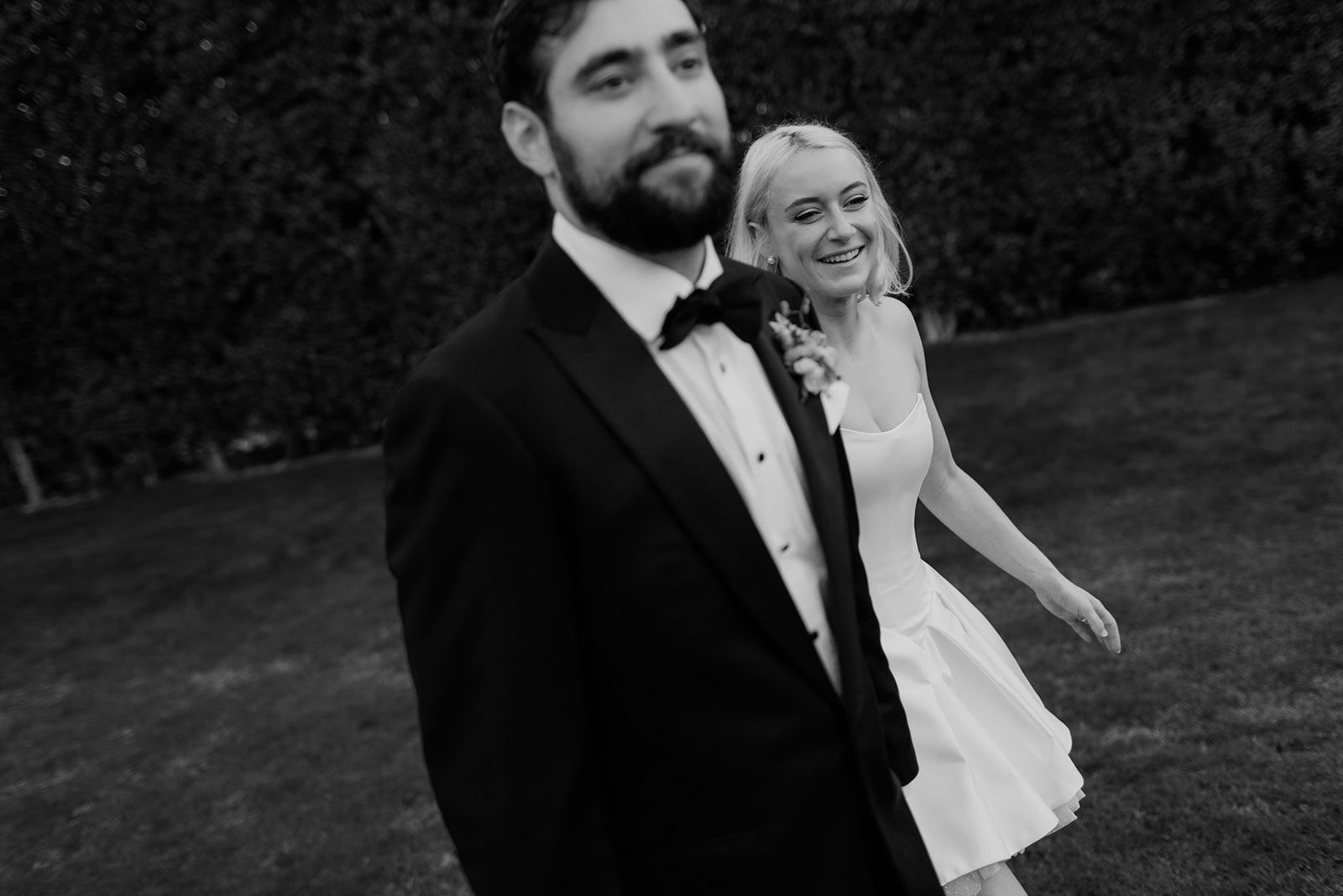 Bride and groom walk hand in hand for their San Diego wedding candid photo.