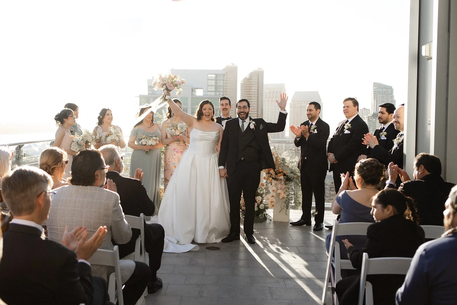 San Diego Gaslamp rooftop wedding ceremony photo of bride and groom waiting at guests that clap.
