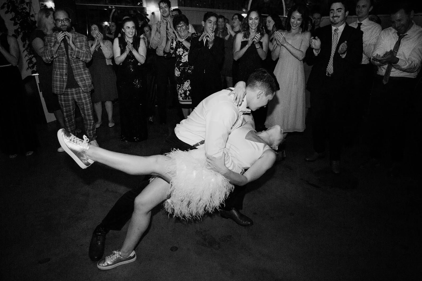 Groom dips bride while dancing at their San Diego wedding reception.