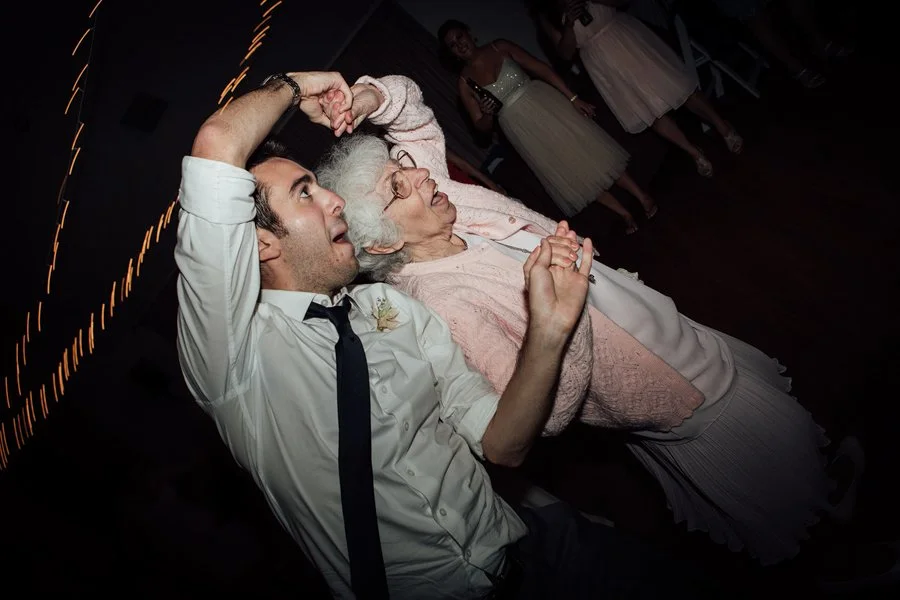 Young man dances with his grandma at a Los Angeles wedding. 