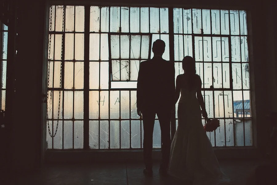 Couple standing in front of a window of downtown San Diego.