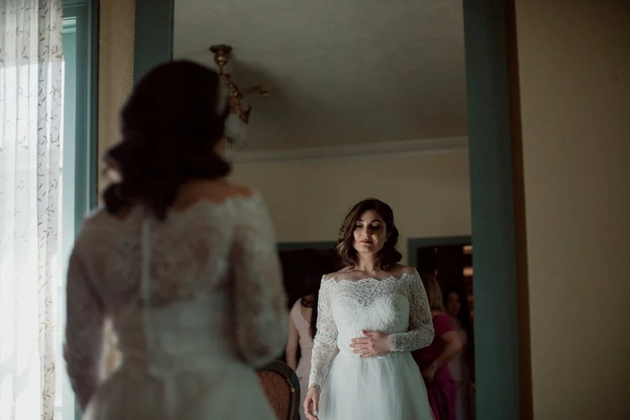 San Diego bride looks into mirror before ceremony.